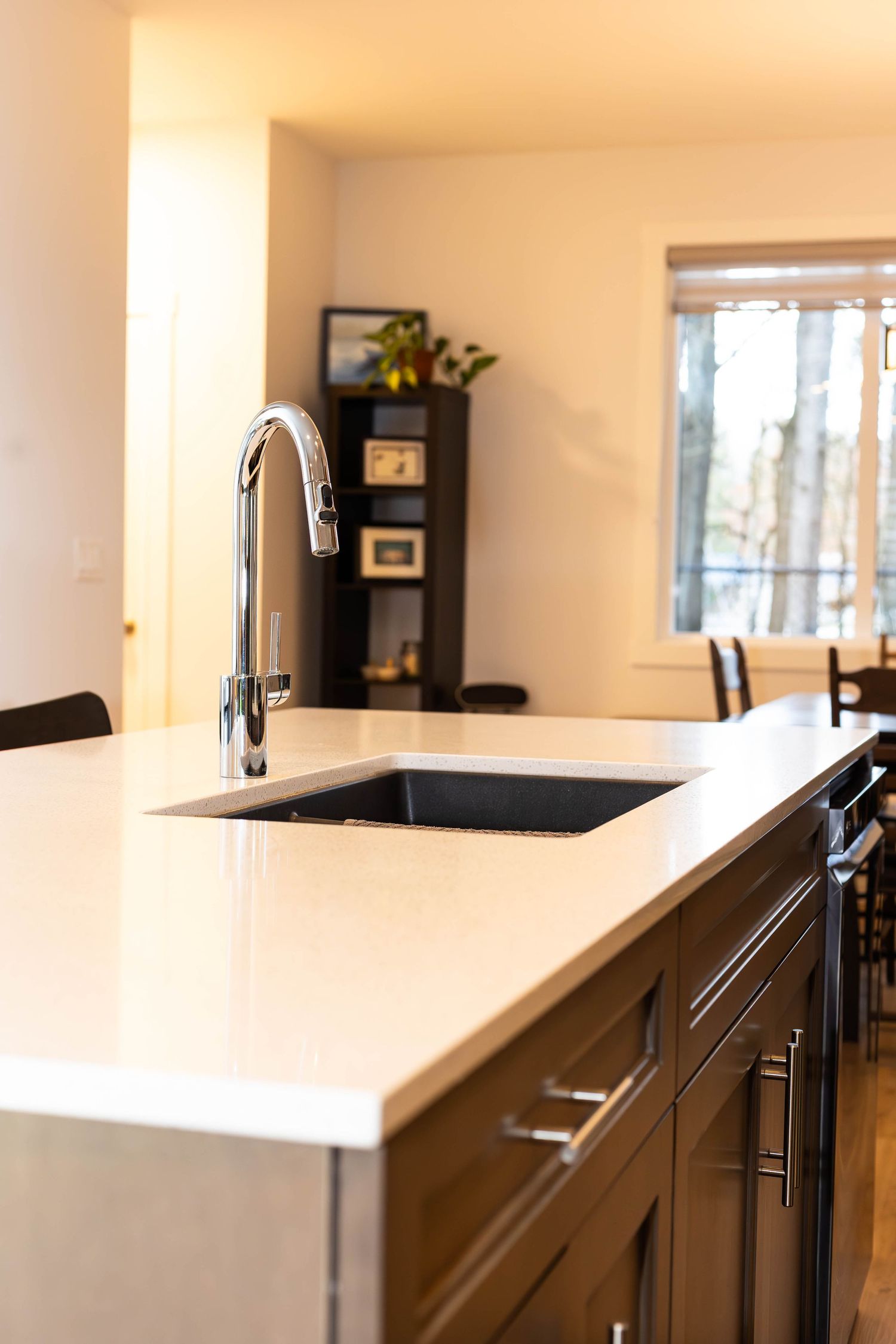 Modern kitchen featuring a sleek chrome faucet and undermount sink with white quartz countertop.