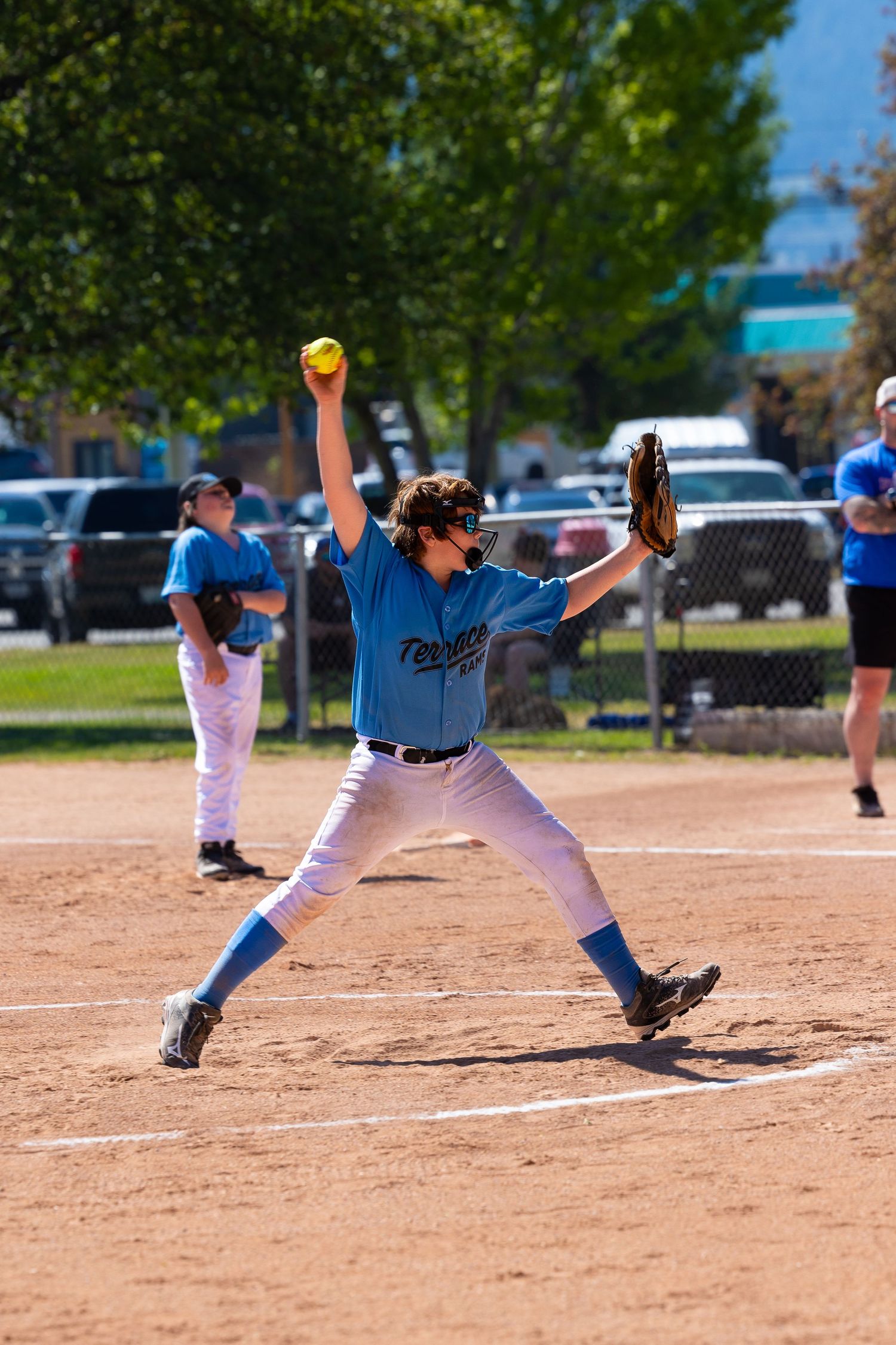 Baseball pitcher in blue jersey and white pants throws a pitch from the mound during a game.