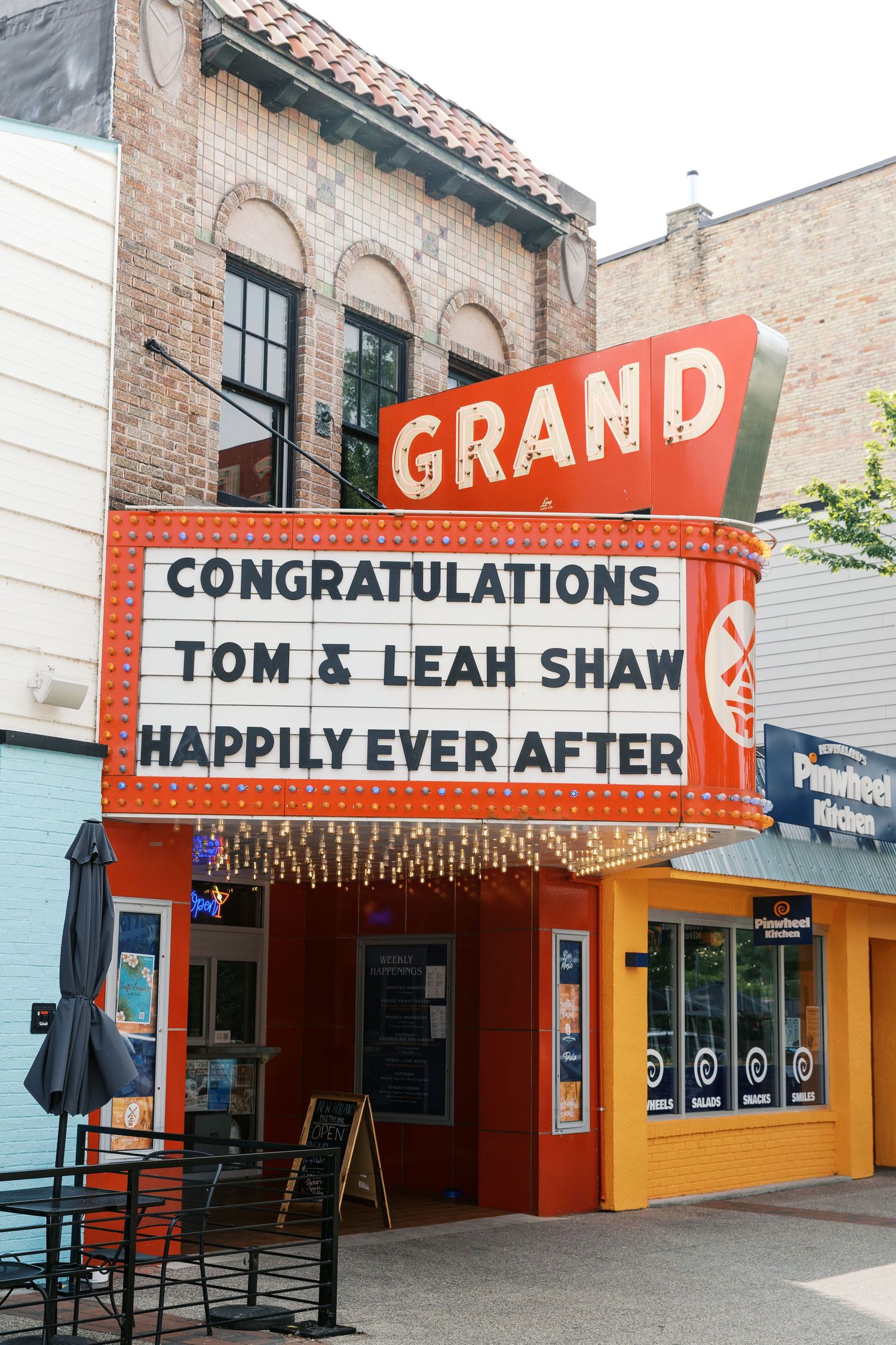 Grand Haven Michigan Elopement Photography under the grand theater marquee sign in downtown grand haven. From, Rayna Photography