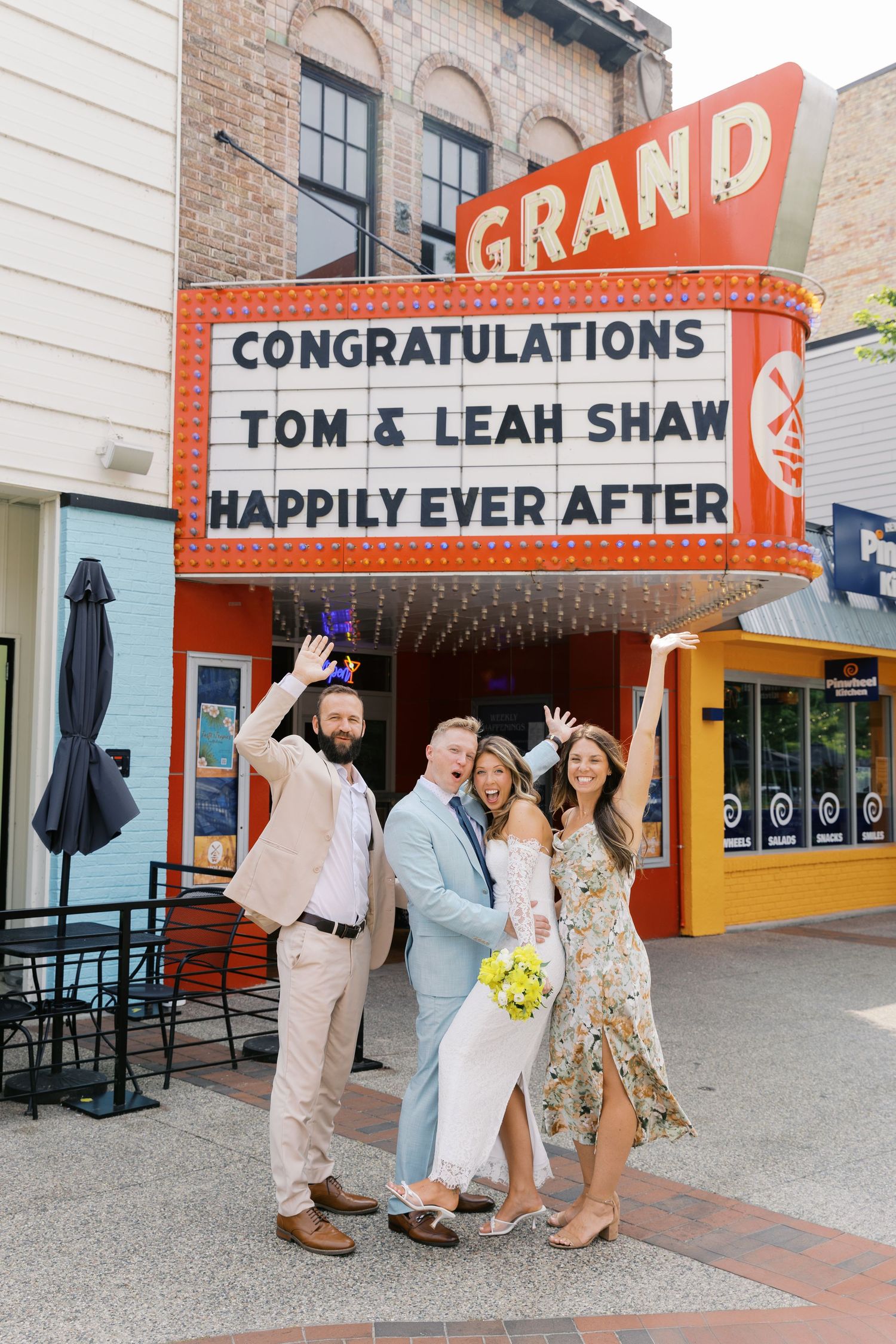 Grand Haven Michigan Elopement Photography under the grand theater marquee sign in downtown grand haven. From, Rayna Photography