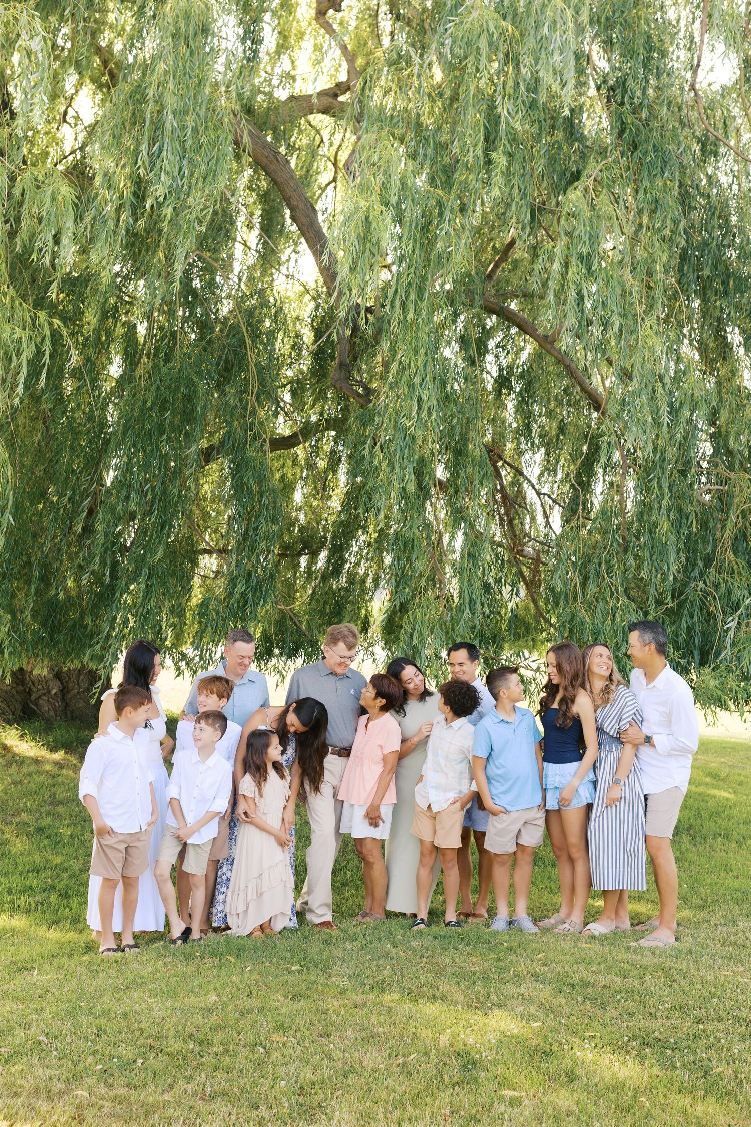 Extended family portrait photography session at harbor island grand haven michigan. Set in the spring with bright colors and willow trees.