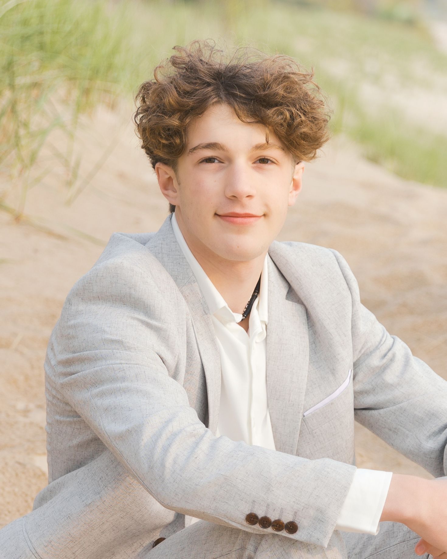 Grand Haven Lake Michigan Beach Senior Portrait Photoshoot. Sand dunes, beach grass, and the great lakes on the boardwalk with a surfboard