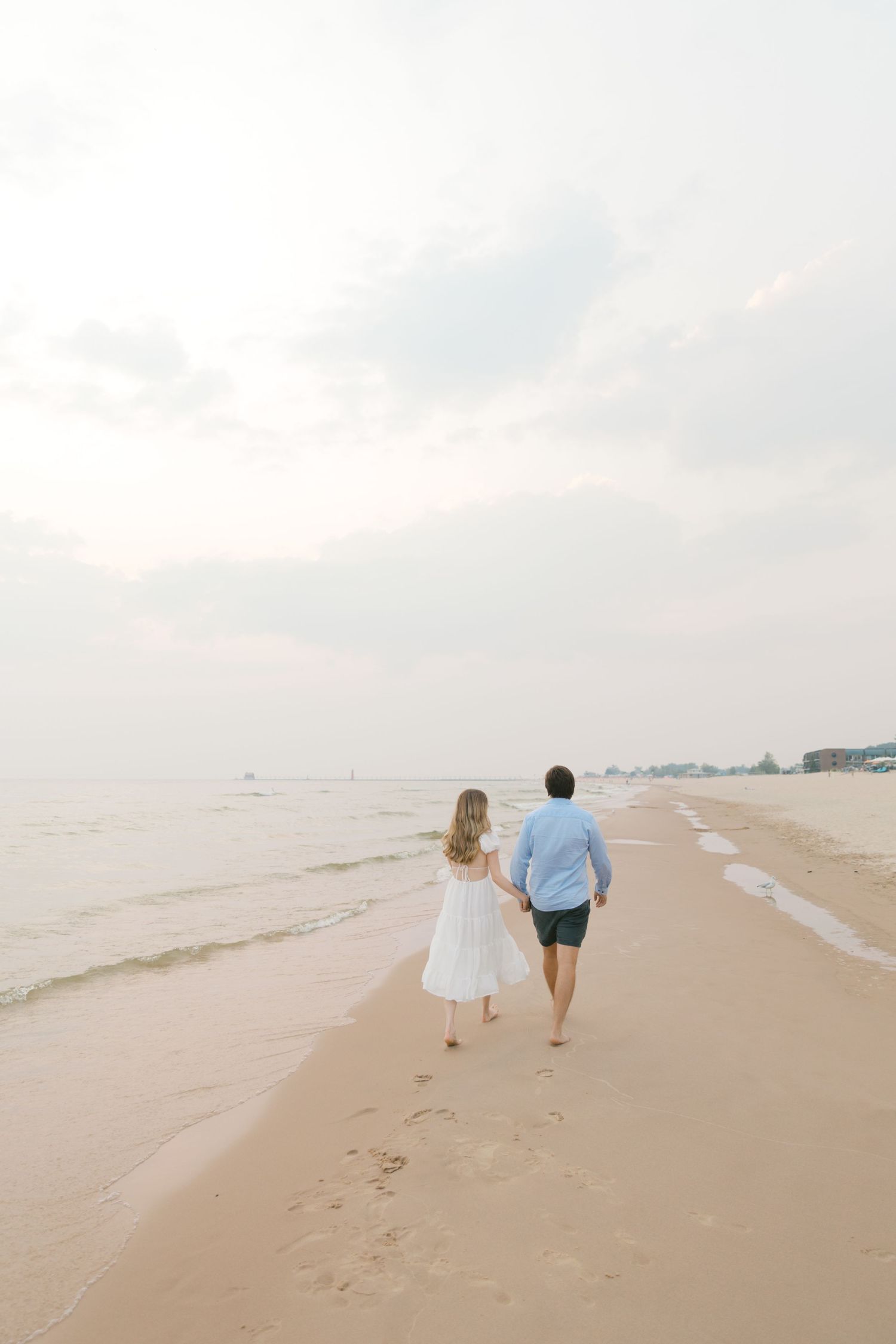 Grand Haven beach and boardwalk coastal midwest town on lake michigan engagement pictures during the summer Grand Haven Wedding photographer