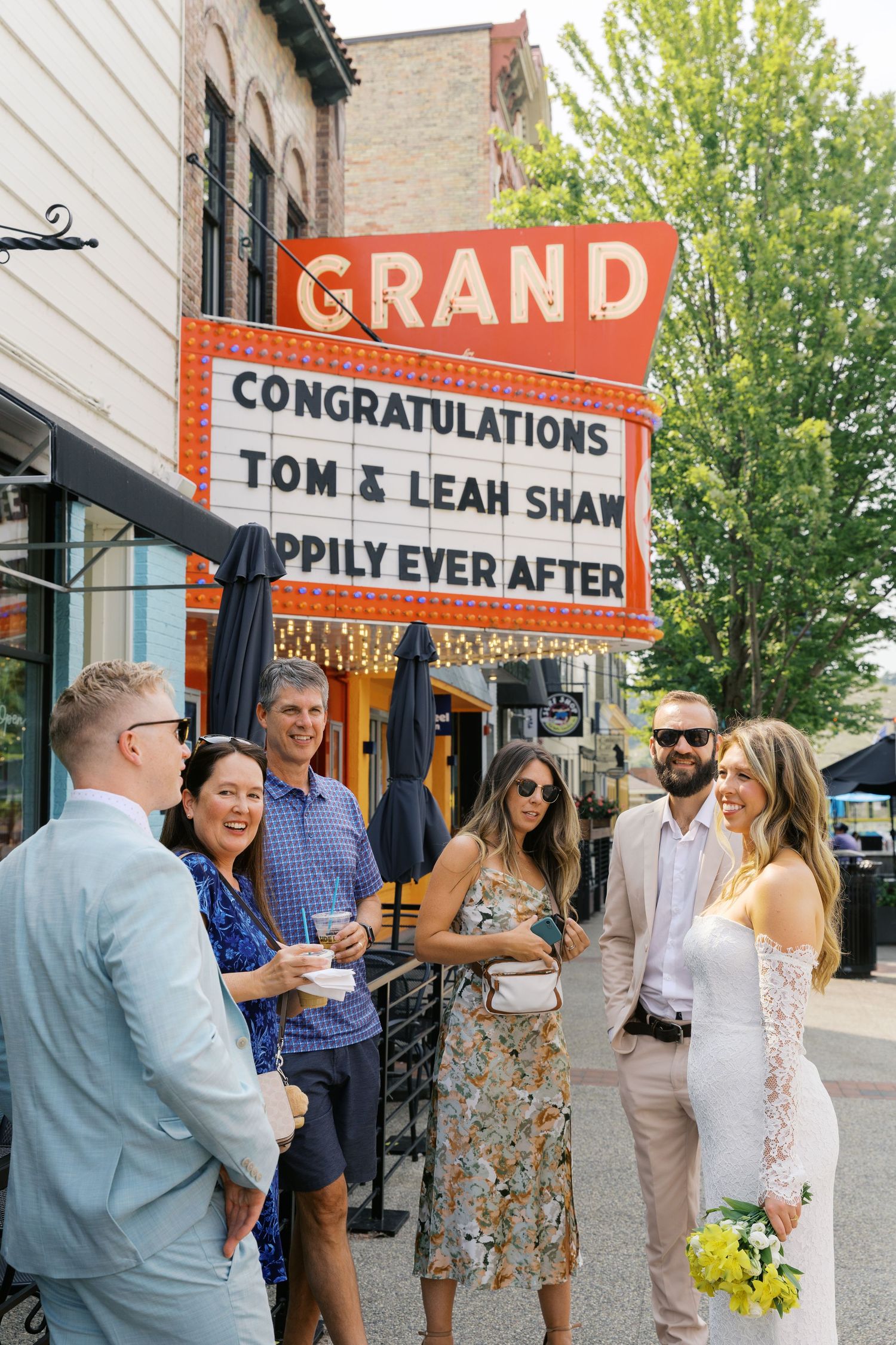 Grand Haven Michigan Elopement Photography under the grand theater marquee sign in downtown grand haven. From, Rayna Photography