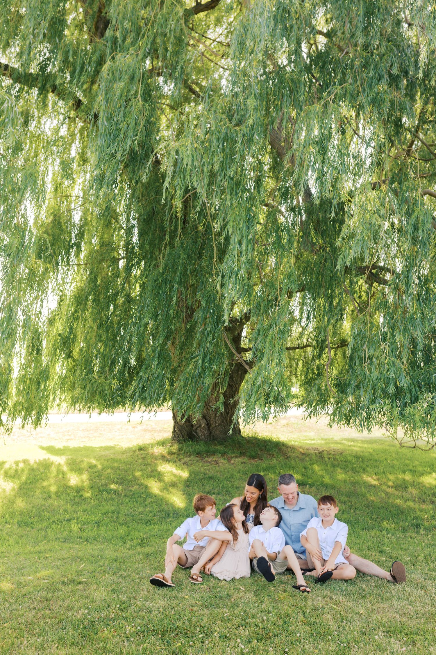 Extended family portrait photography session at harbor island grand haven michigan. Set in the spring with bright colors and willow trees.