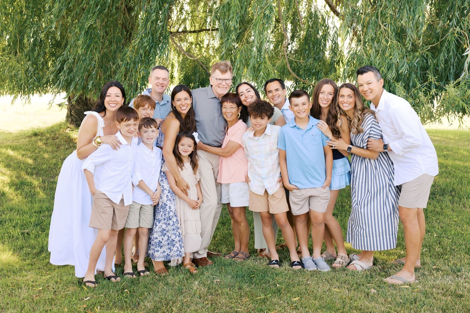 Extended family portrait photography session at harbor island grand haven michigan. Set in the spring with bright colors and willow trees.