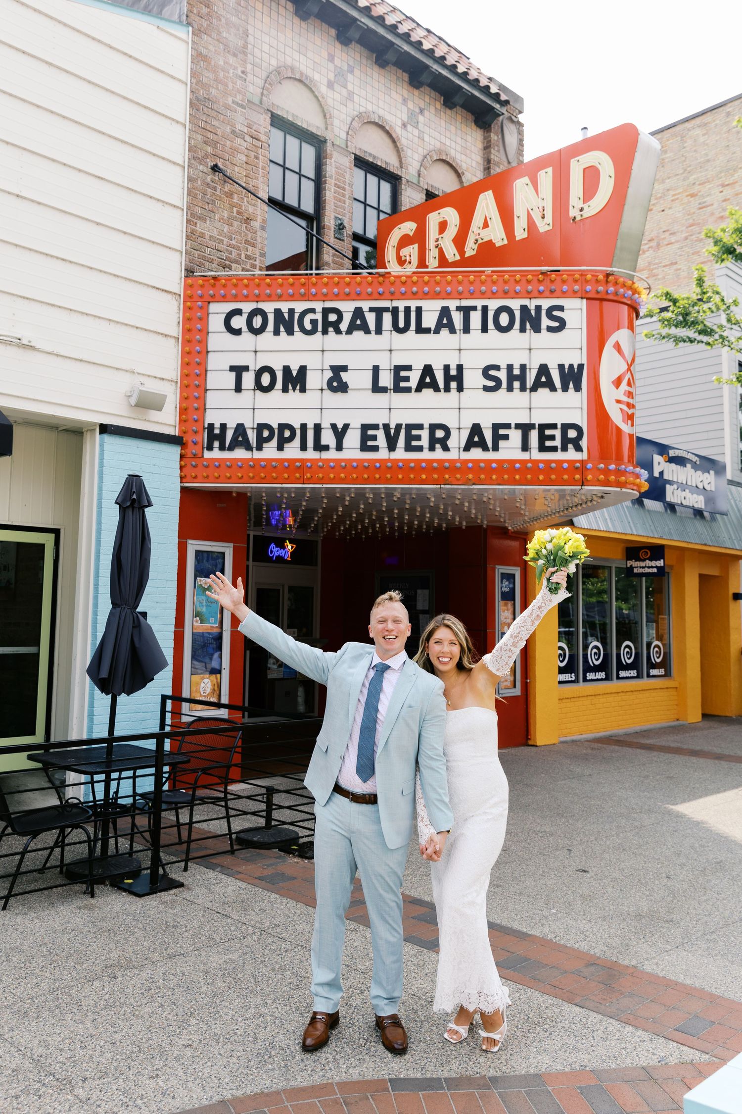 Grand Haven Michigan Elopement Photography under the grand theater marquee sign in downtown grand haven. From, Rayna Photography