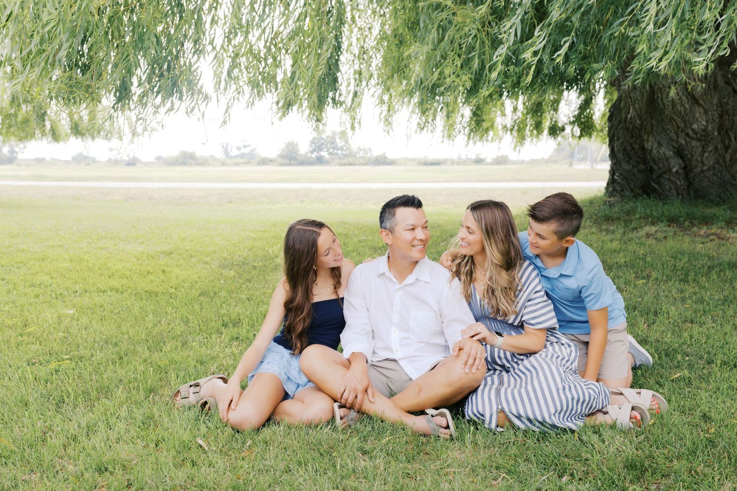Extended family portrait photography session at harbor island grand haven michigan. Set in the spring with bright colors and willow trees.