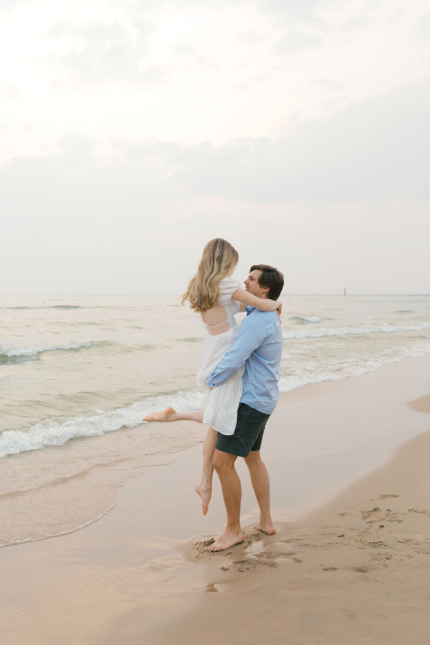 Grand Haven beach and boardwalk coastal midwest town on lake michigan engagement pictures during the summer Grand Haven Wedding photographer