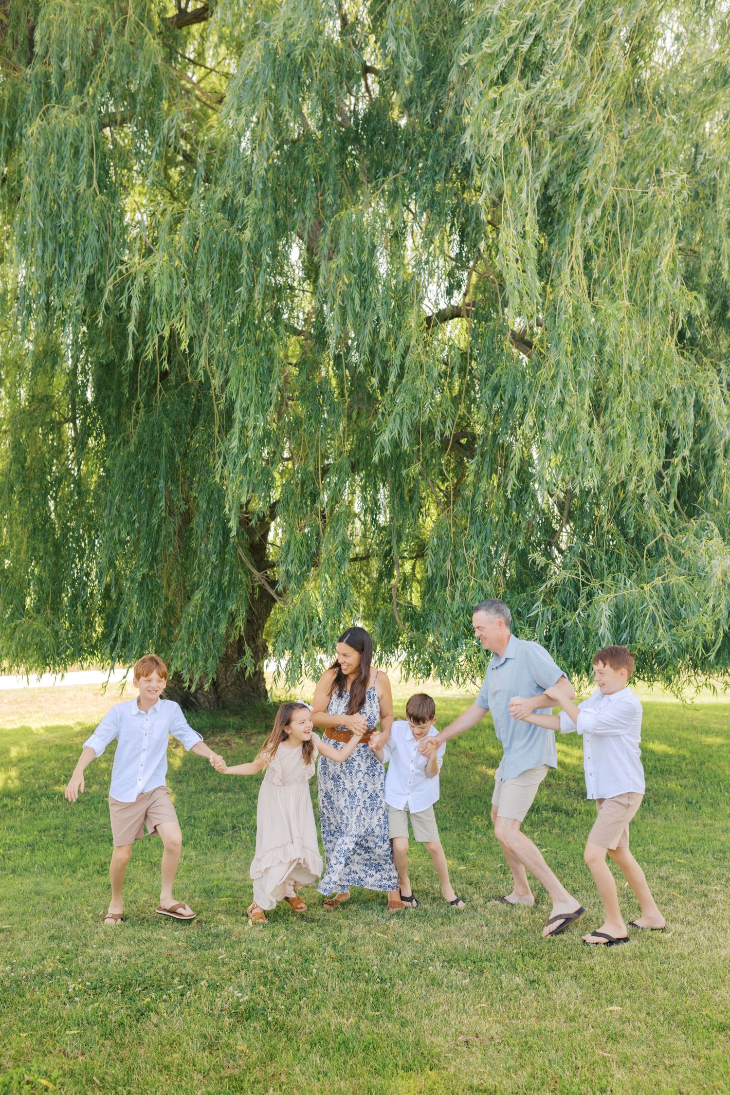 Extended family portrait photography session at harbor island grand haven michigan. Set in the spring with bright colors and willow trees.