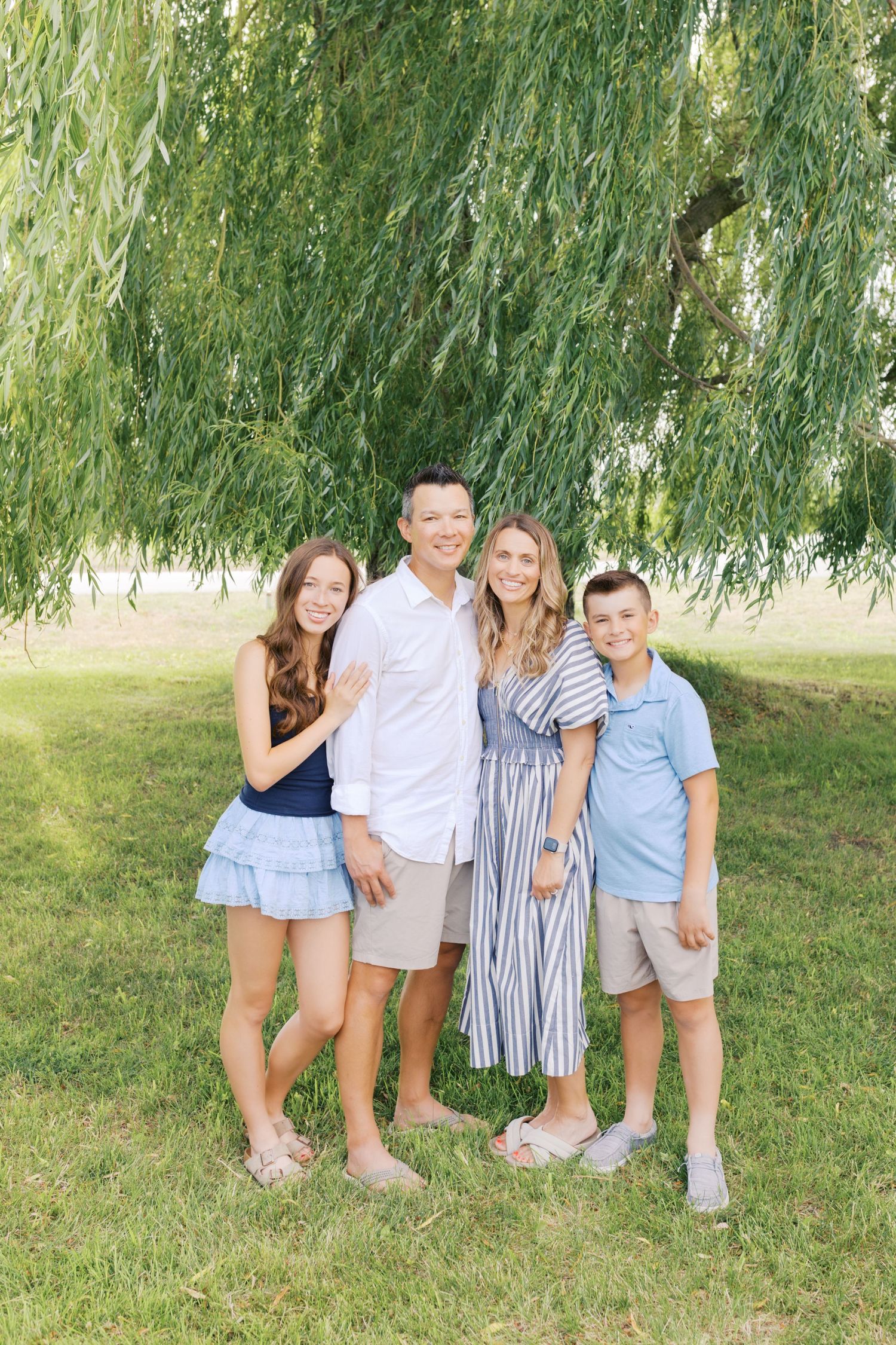 Extended family portrait photography session at harbor island grand haven michigan. Set in the spring with bright colors and willow trees.
