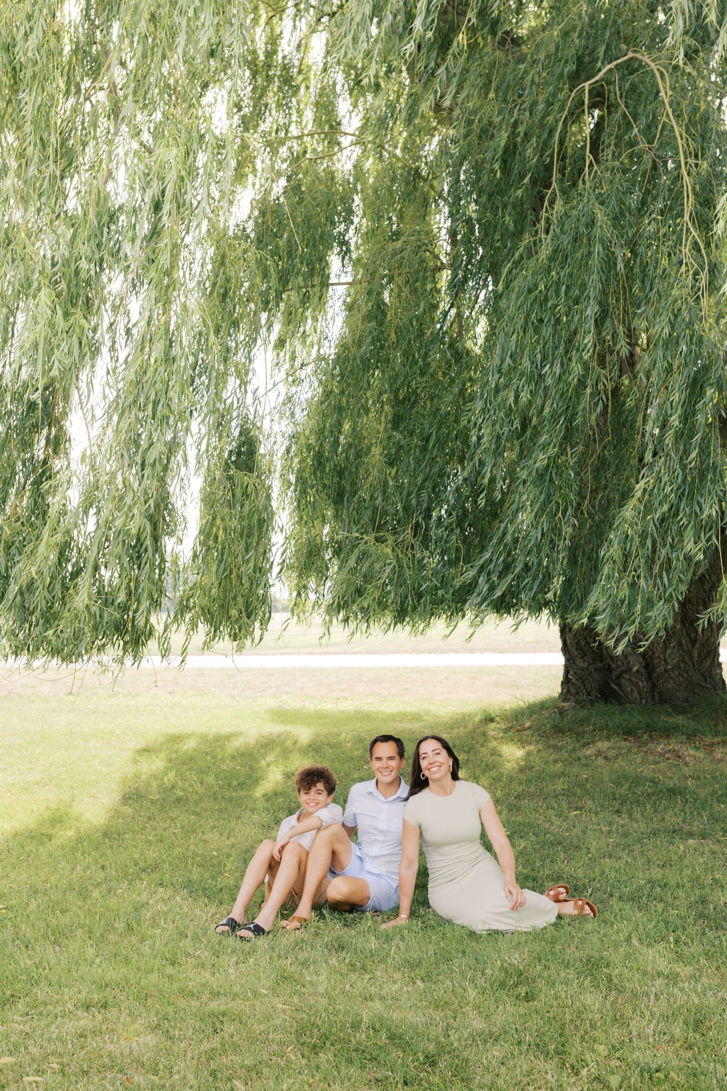 Extended family portrait photography session at harbor island grand haven michigan. Set in the spring with bright colors and willow trees.