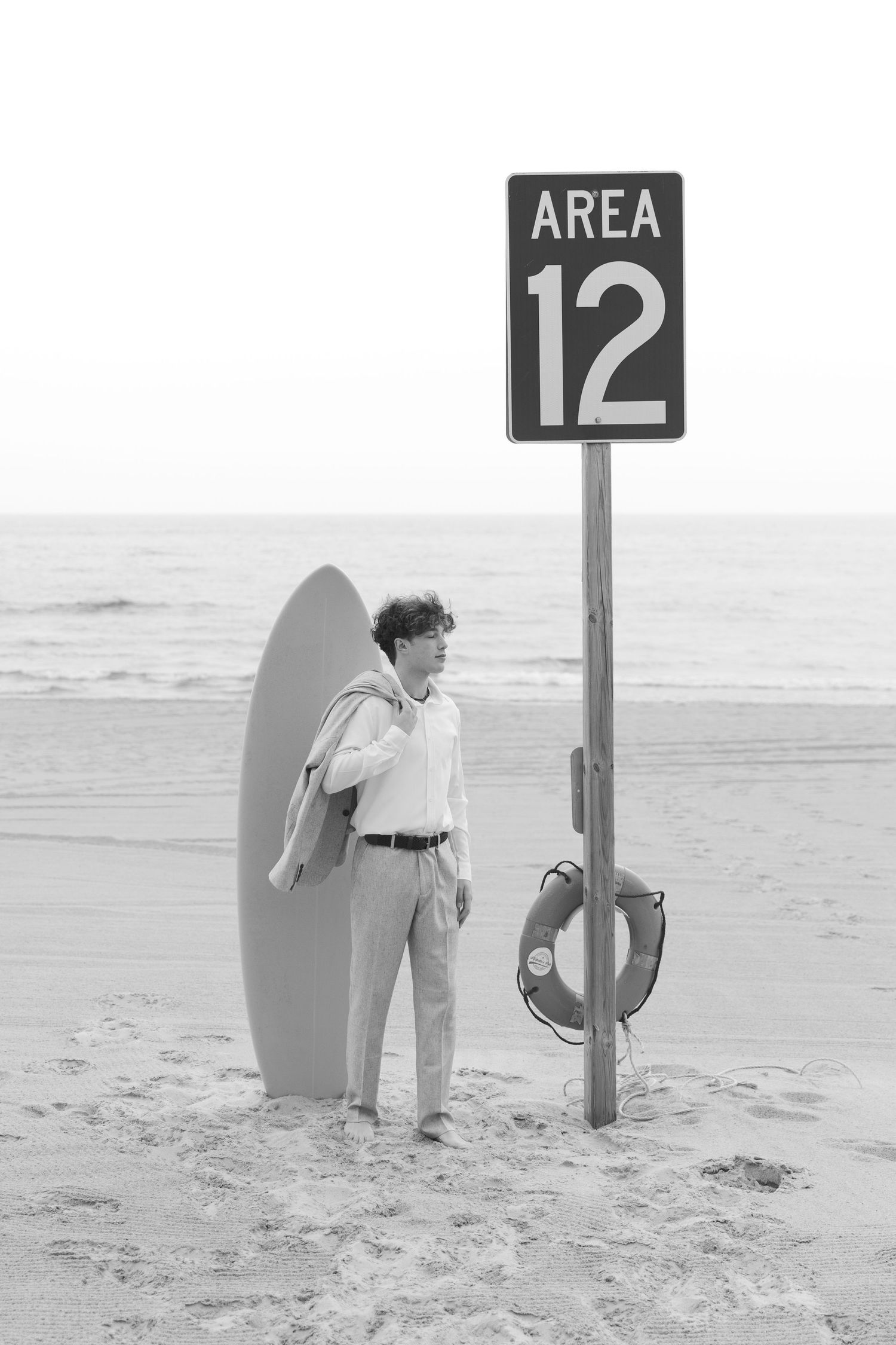 Grand Haven Lake Michigan Beach Senior Portrait Photoshoot. Sand dunes, beach grass, and the great lakes on the boardwalk with a surfboard