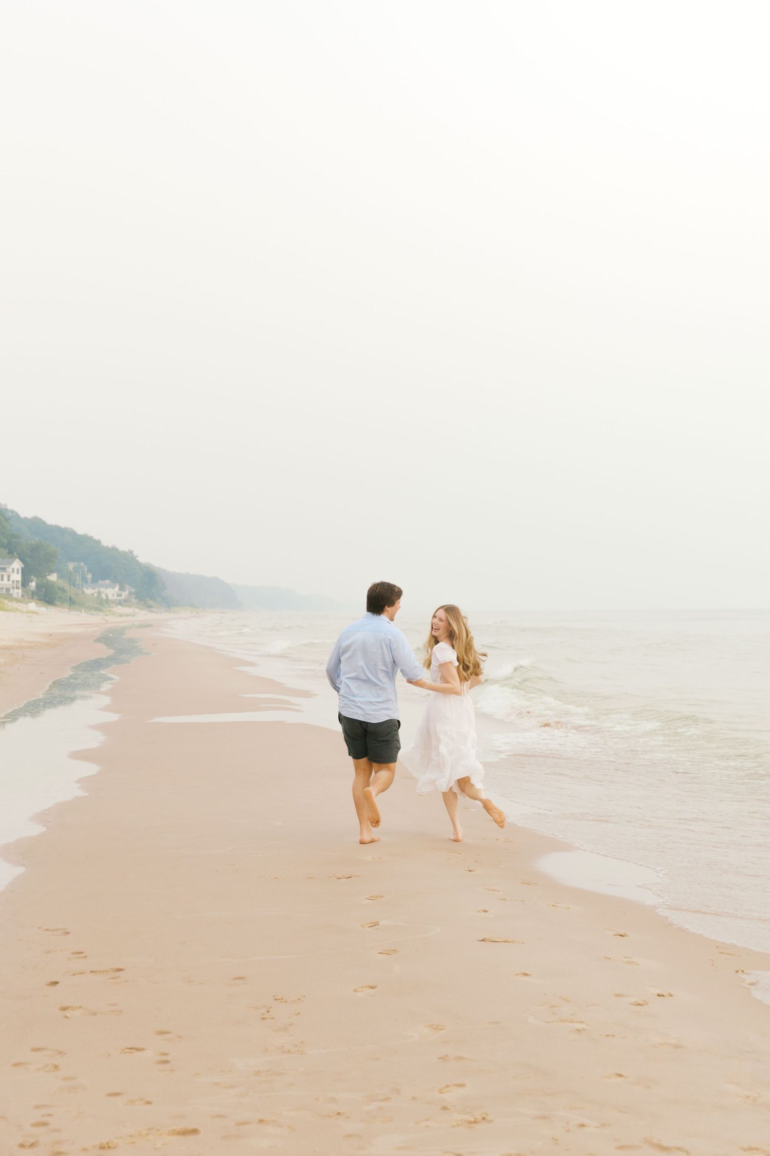 Grand Haven beach and boardwalk coastal midwest town on lake michigan engagement pictures during the summer Grand Haven Wedding photographer