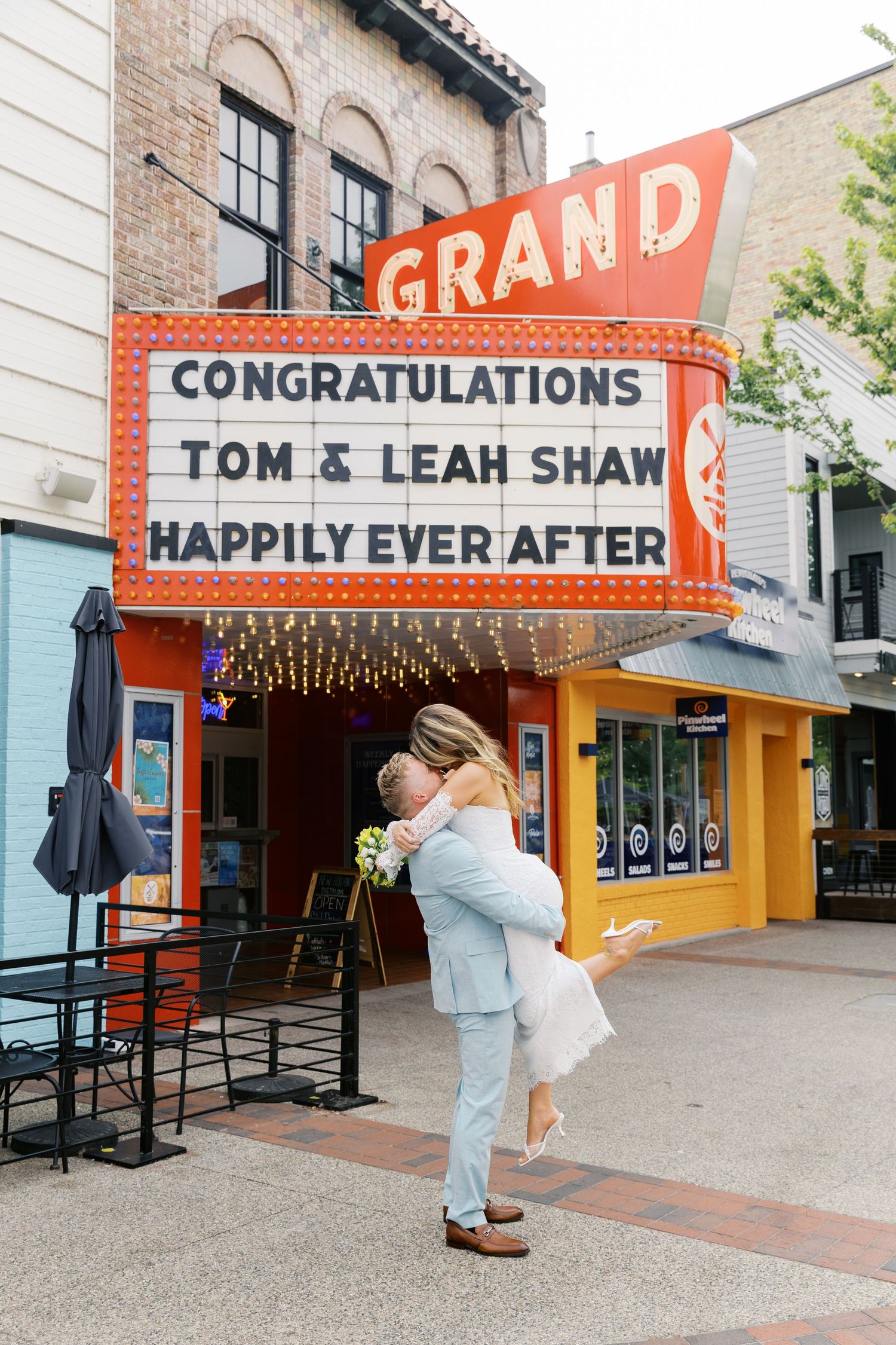 Grand Haven Michigan Elopement Photography under the grand theater marquee sign in downtown grand haven. From, Rayna Photography