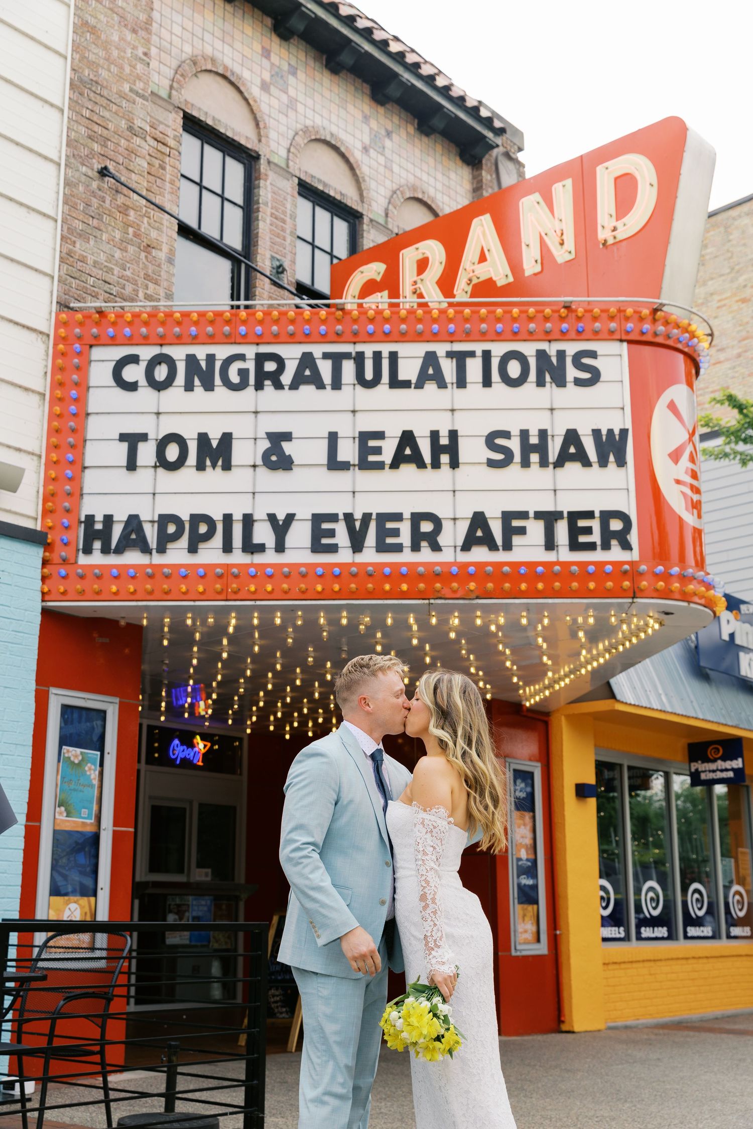 Grand Haven Michigan Elopement Photography under the grand theater marquee sign in downtown grand haven. From, Rayna Photography