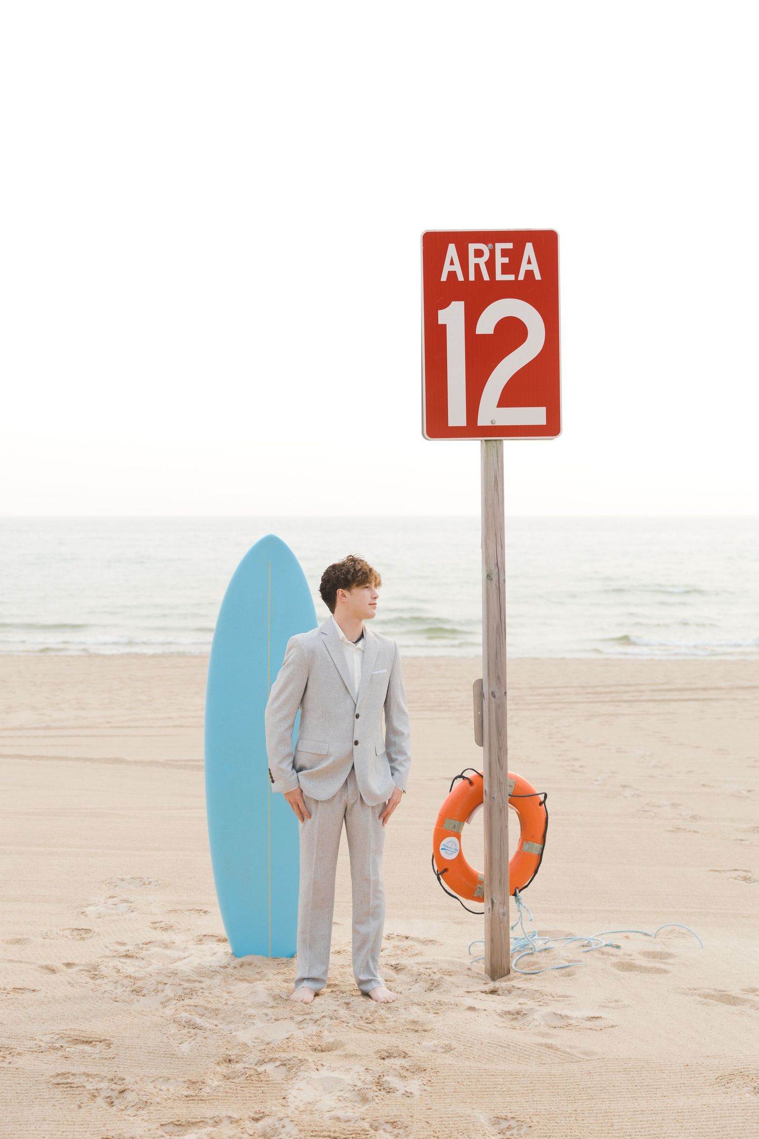 Grand Haven Lake Michigan Beach Senior Portrait Photoshoot. Sand dunes, beach grass, and the great lakes on the boardwalk with a surfboard