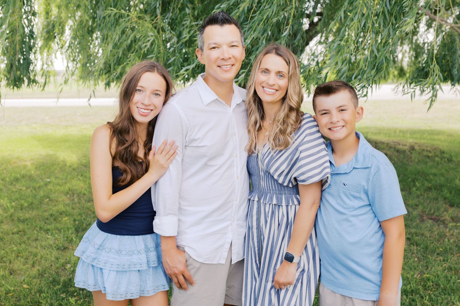 Extended family portrait photography session at harbor island grand haven michigan. Set in the spring with bright colors and willow trees.