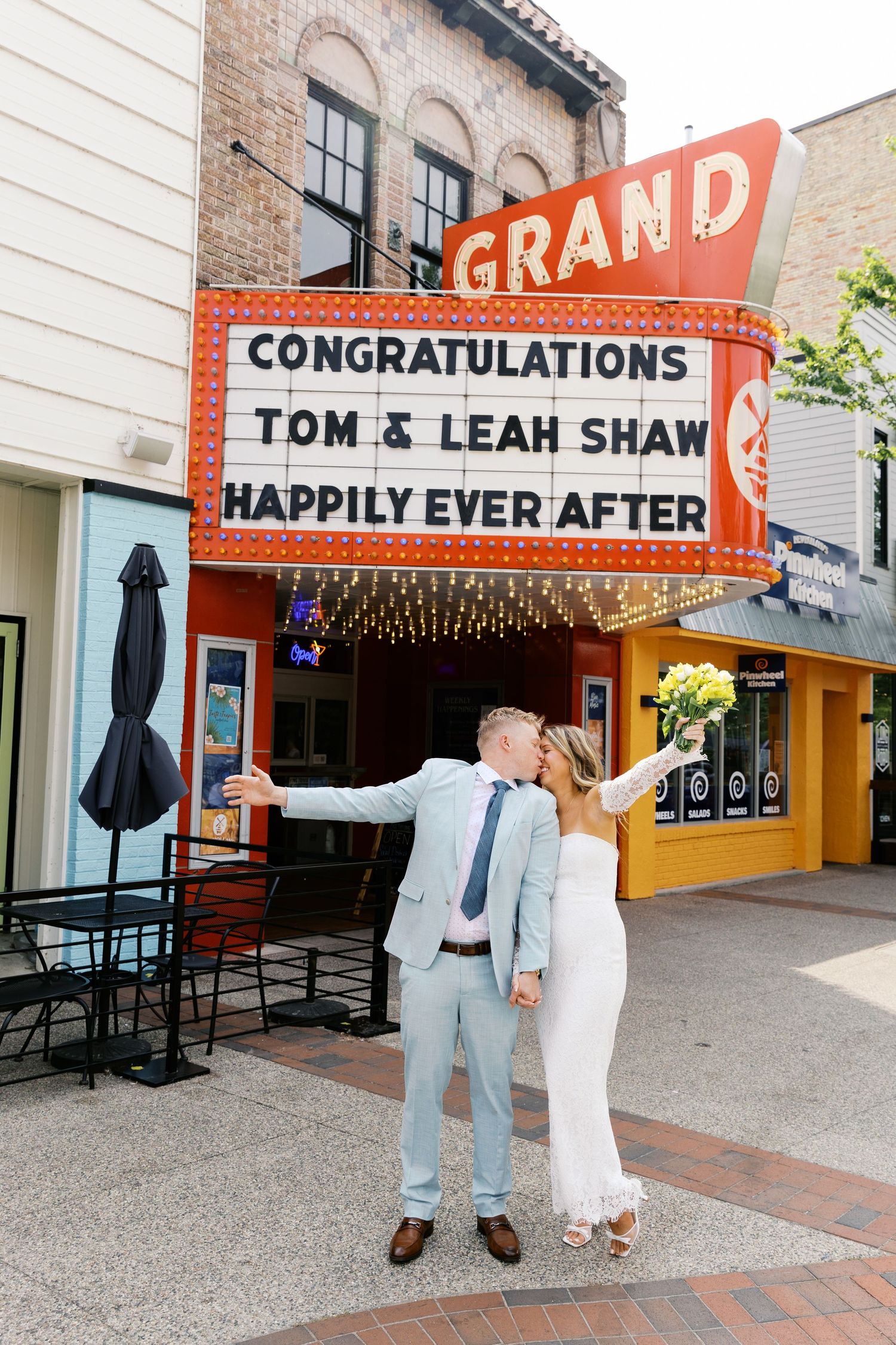 Grand Haven Michigan Elopement Photography under the grand theater marquee sign in downtown grand haven. From, Rayna Photography