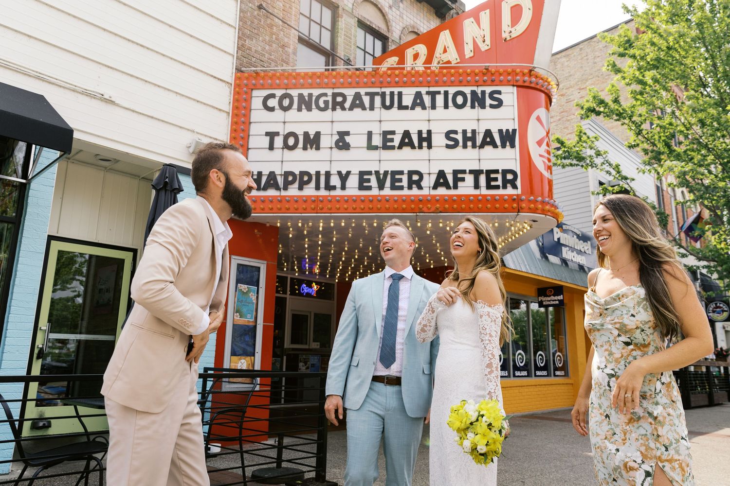 Grand Haven Michigan Elopement Photography under the grand theater marquee sign in downtown grand haven. From, Rayna Photography