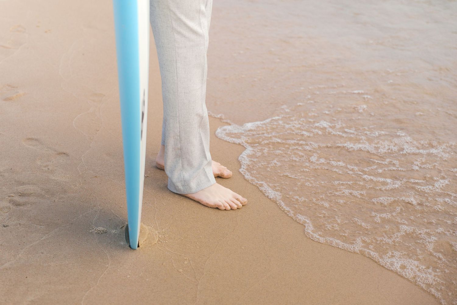 Grand Haven Lake Michigan Beach Senior Portrait Photoshoot. Sand dunes, beach grass, and the great lakes on the boardwalk with a surfboard