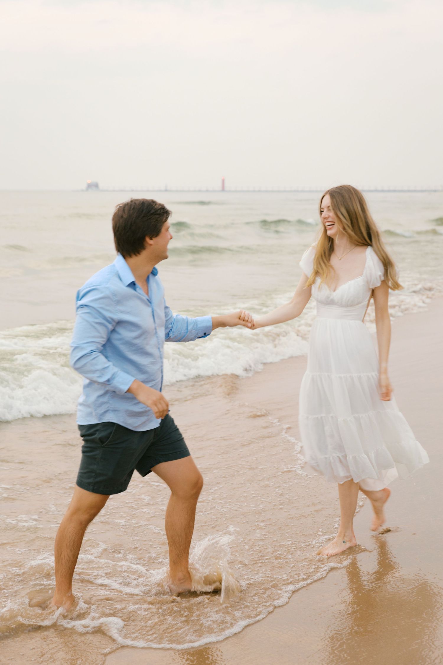 Grand Haven beach and boardwalk coastal midwest town on lake michigan engagement pictures during the summer Grand Haven Wedding photographer