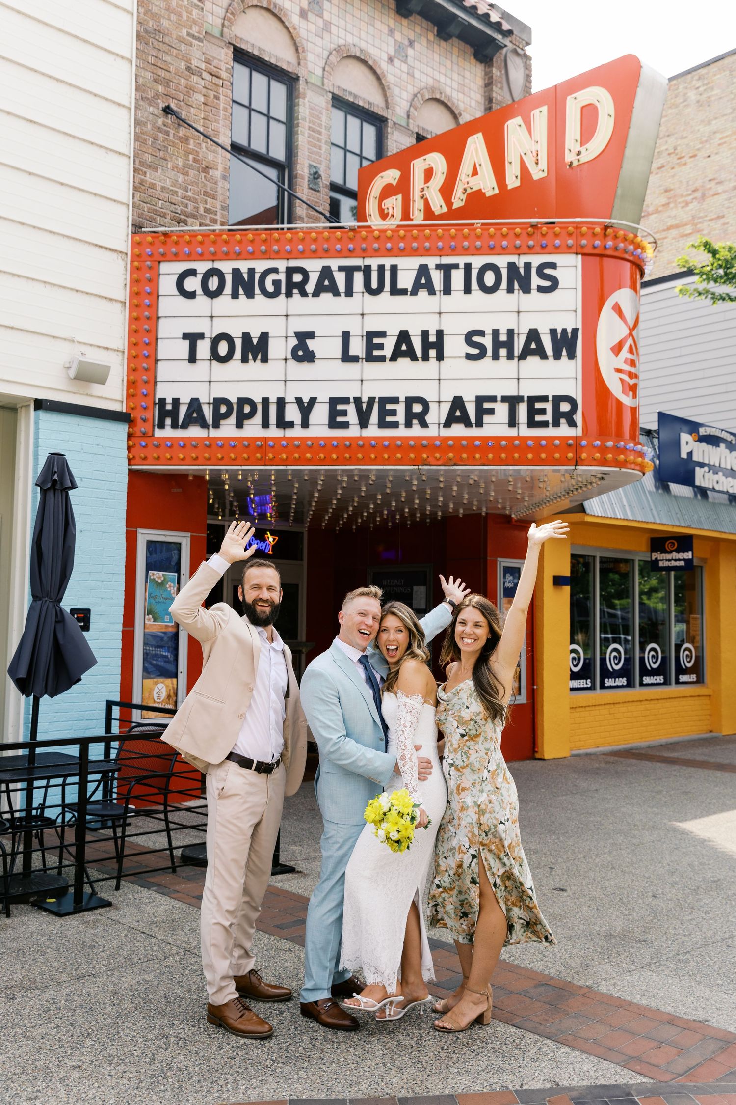 Grand Haven Michigan Elopement Photography under the grand theater marquee sign in downtown grand haven. From, Rayna Photography