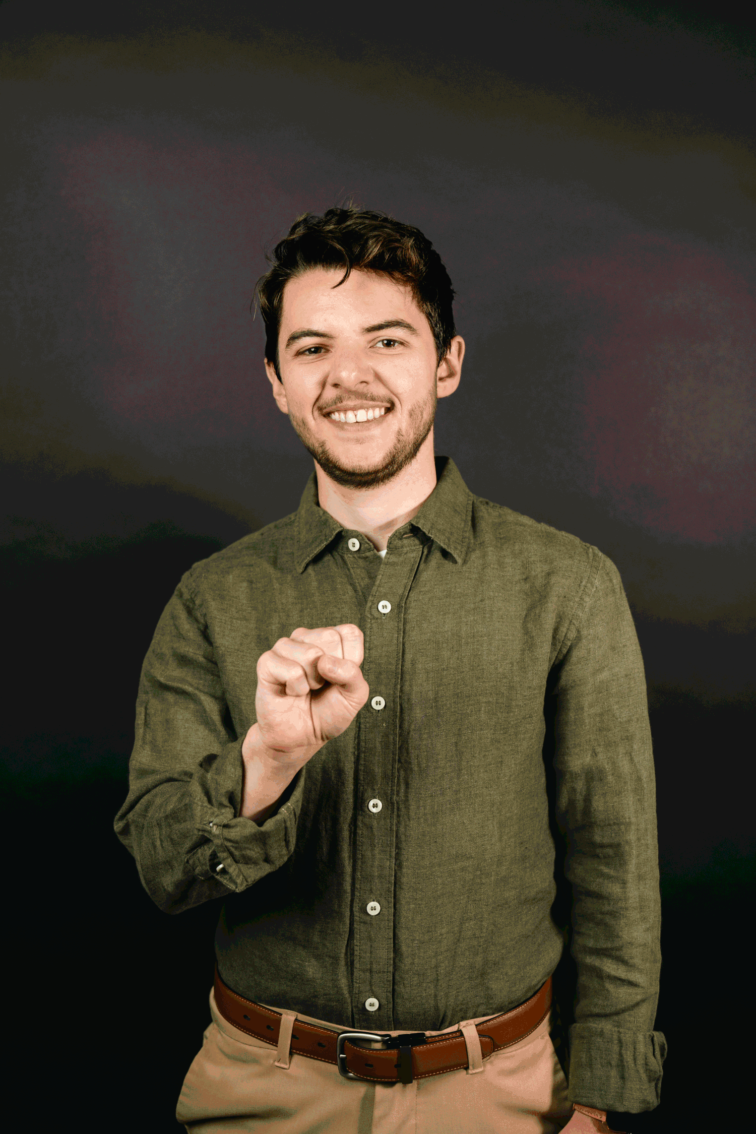 A person in an olive green button-up shirt poses against a dark background showing different expressions and gestures.