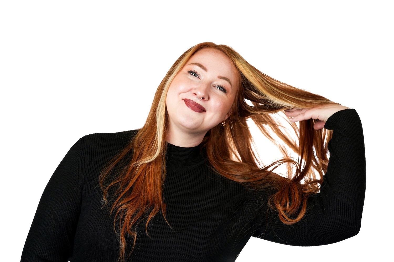 Energetic portrait showing movement of long red hair against white background.