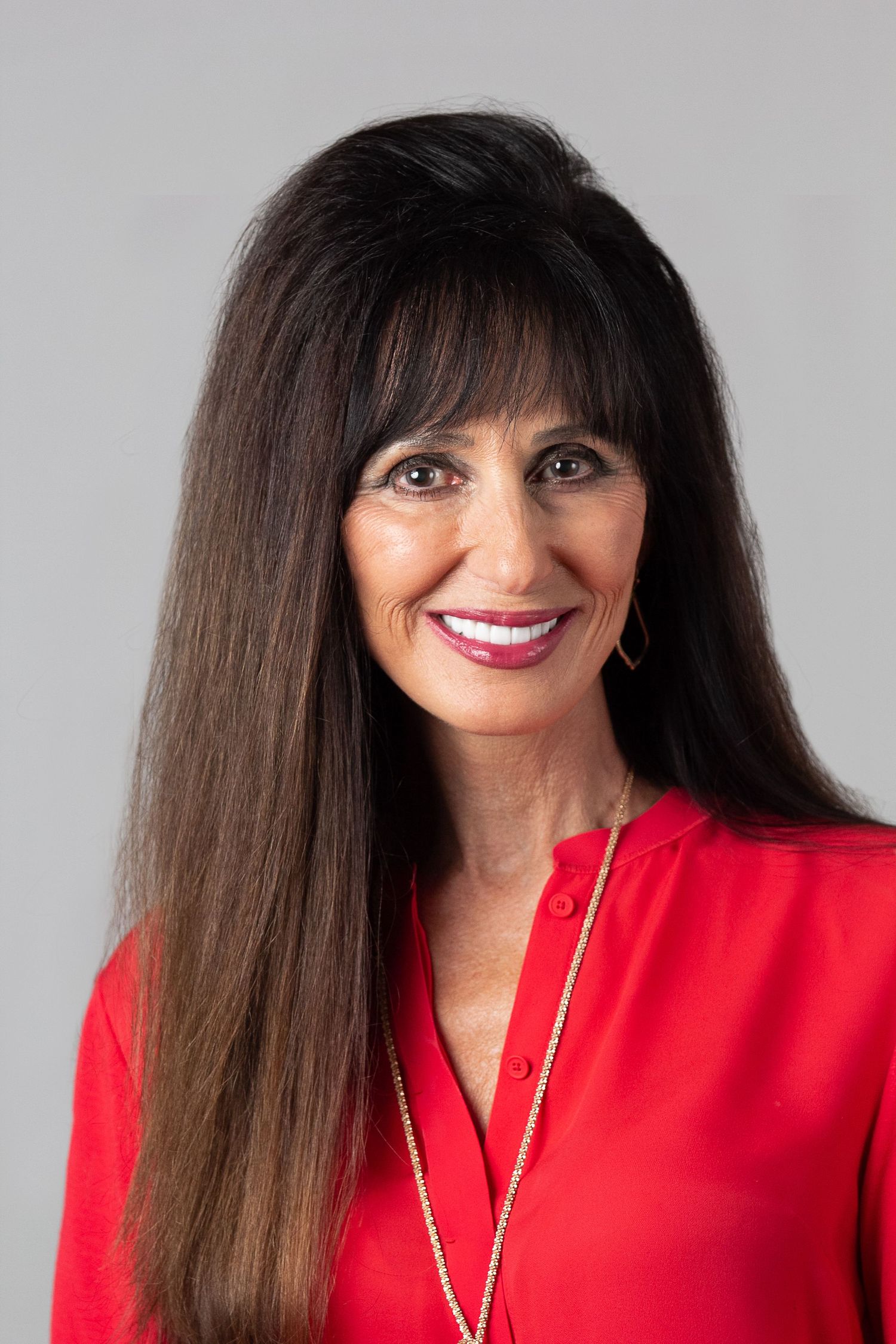 A sequence of professional portraits featuring someone in a vibrant red top with long dark hair and bright smile.