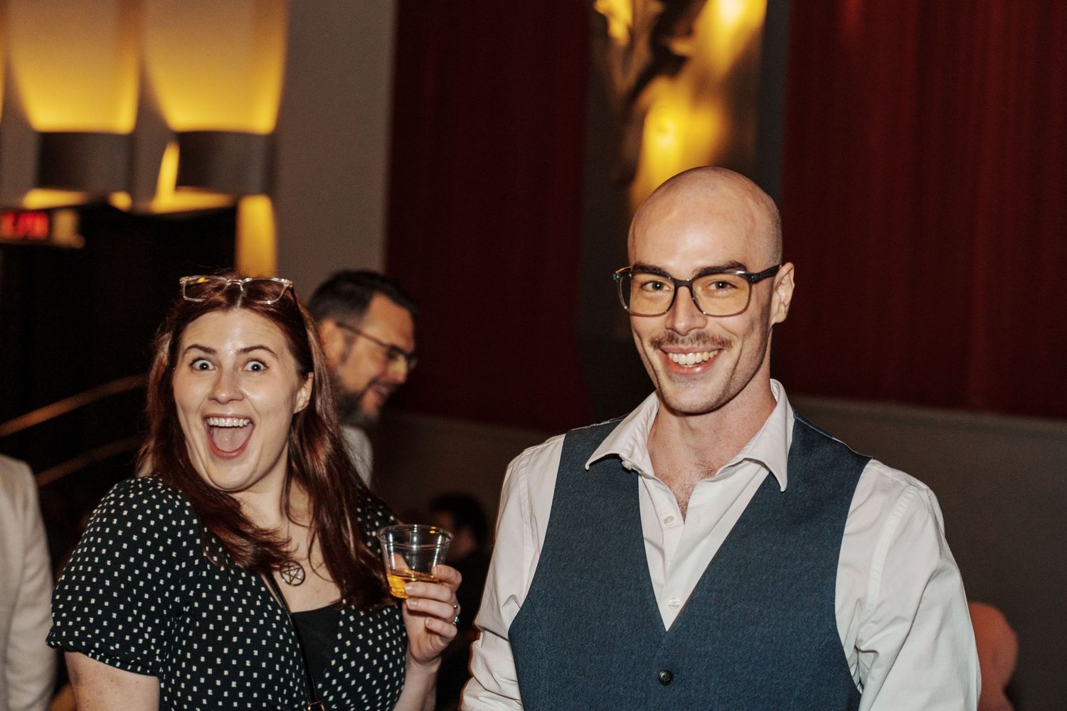 Event attendees socializing and laughing together at an indoor gathering.