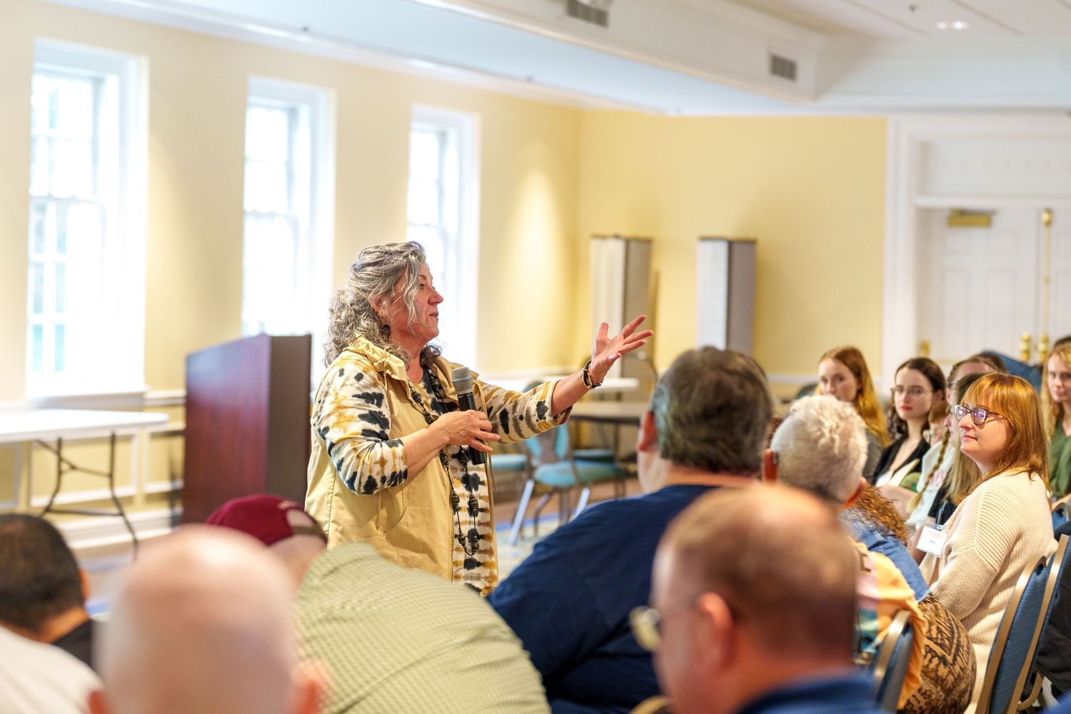 People gather in a bright church hall or community room for what appears to be a meeting or event.