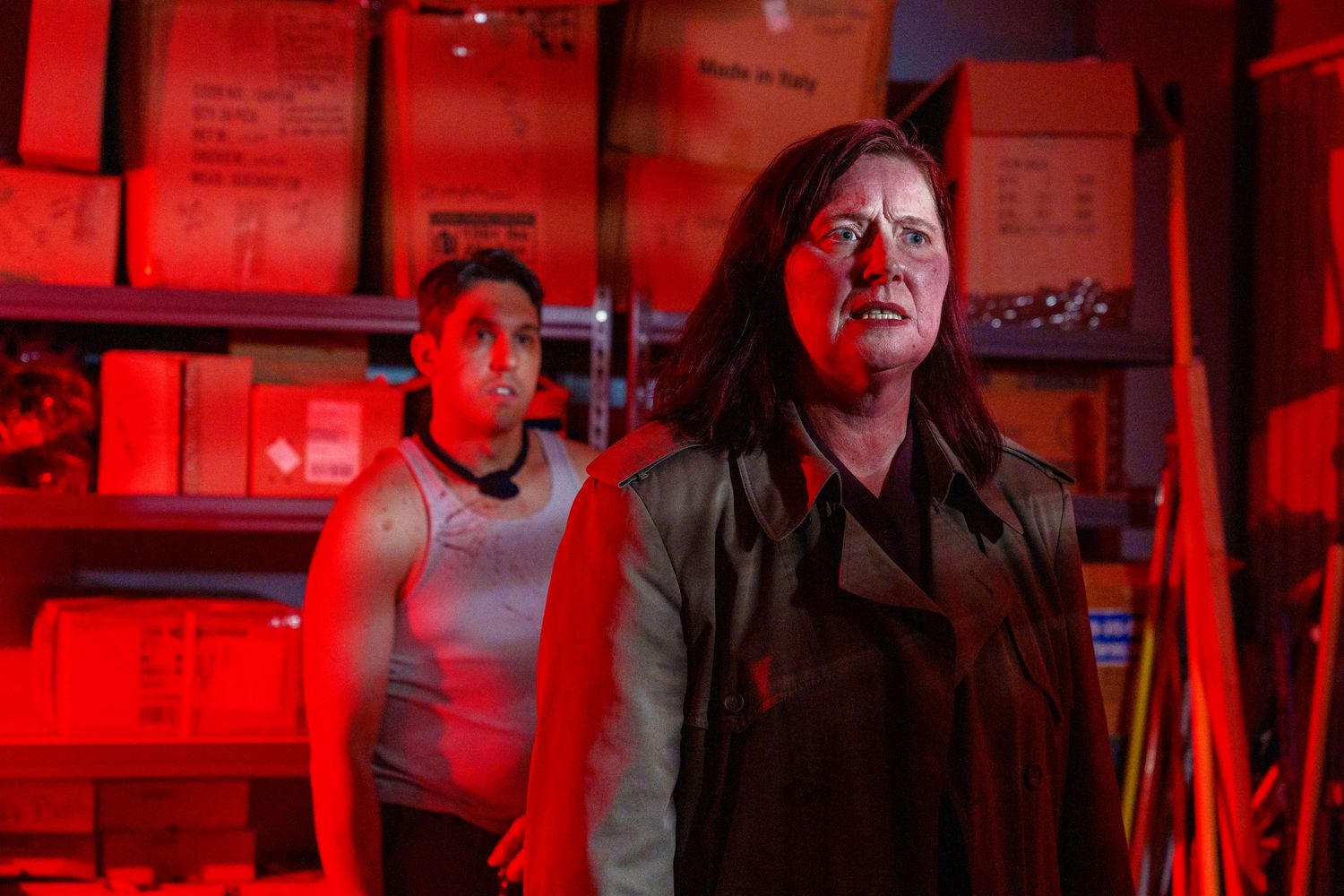 Film production scene bathed in dramatic red lighting with equipment visible.