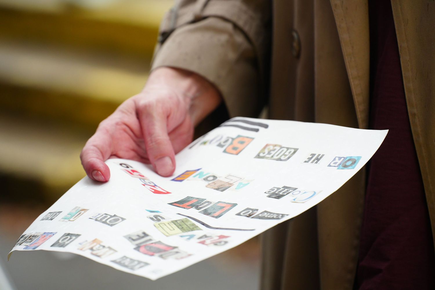 Person holding a sheet of colorful postage stamps, displaying various denominations and designs.