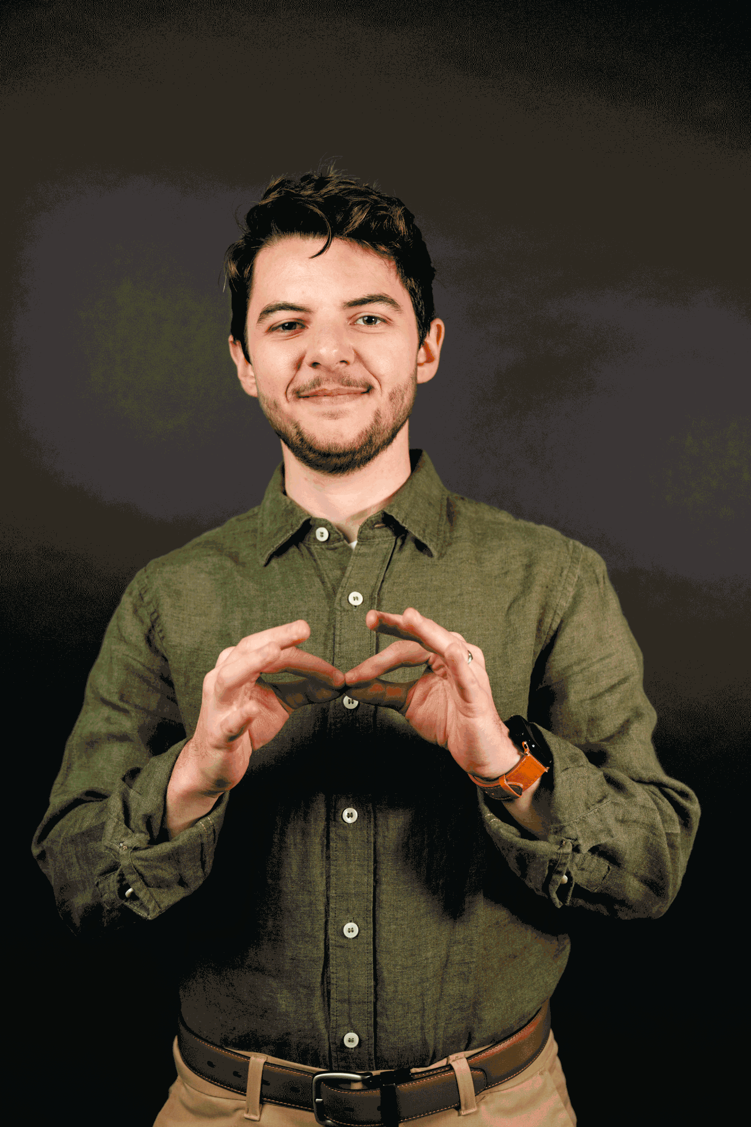 Someone wearing an olive green button-down shirt demonstrates sign language gestures in a sequence against a dark background.