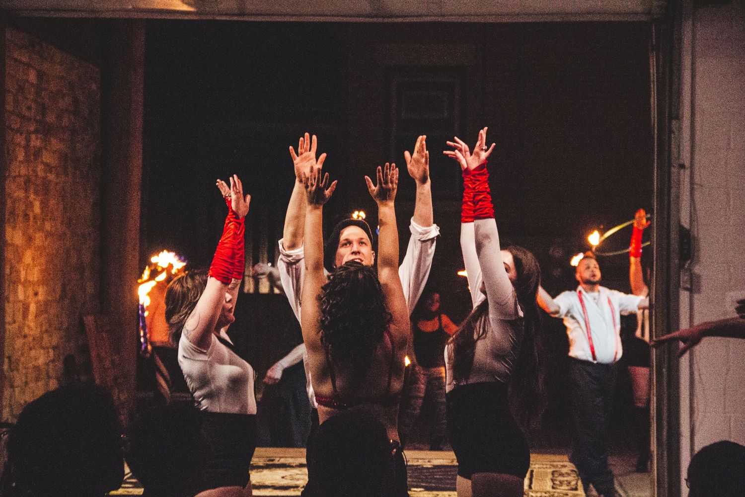 Audience silhouettes with raised hands during theatrical performance.