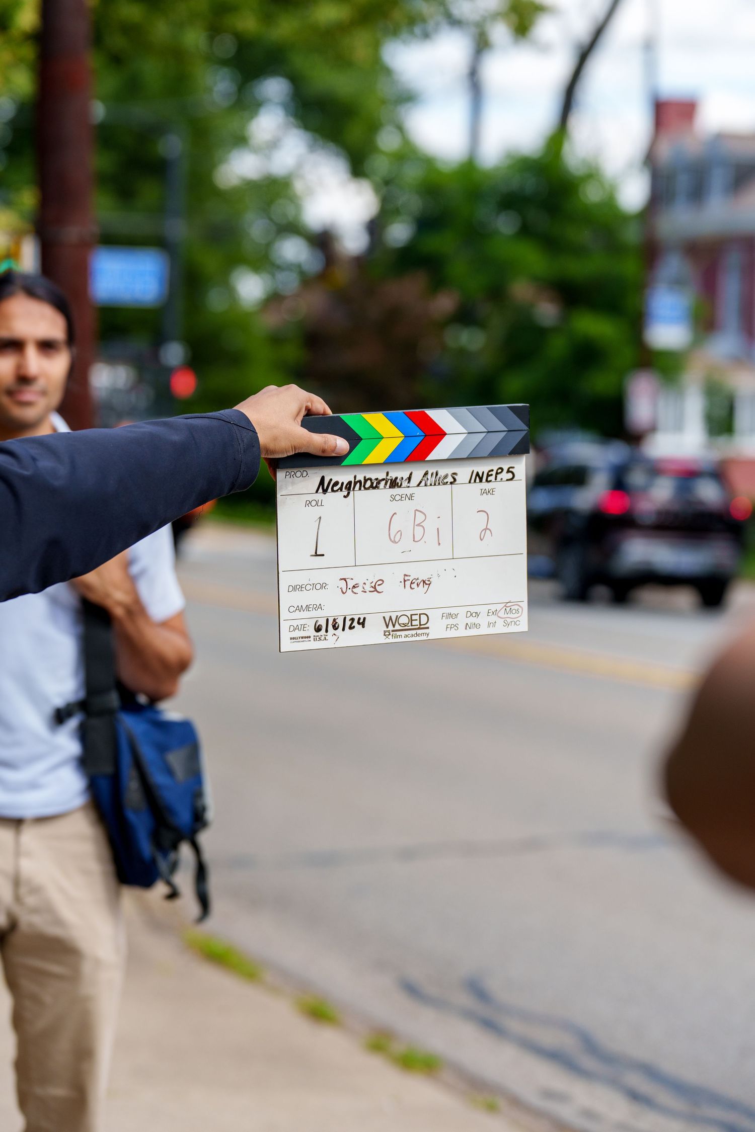 A film clapperboard held on a street set, showing scene details for director Jesse Froy, dated 6/13/24.