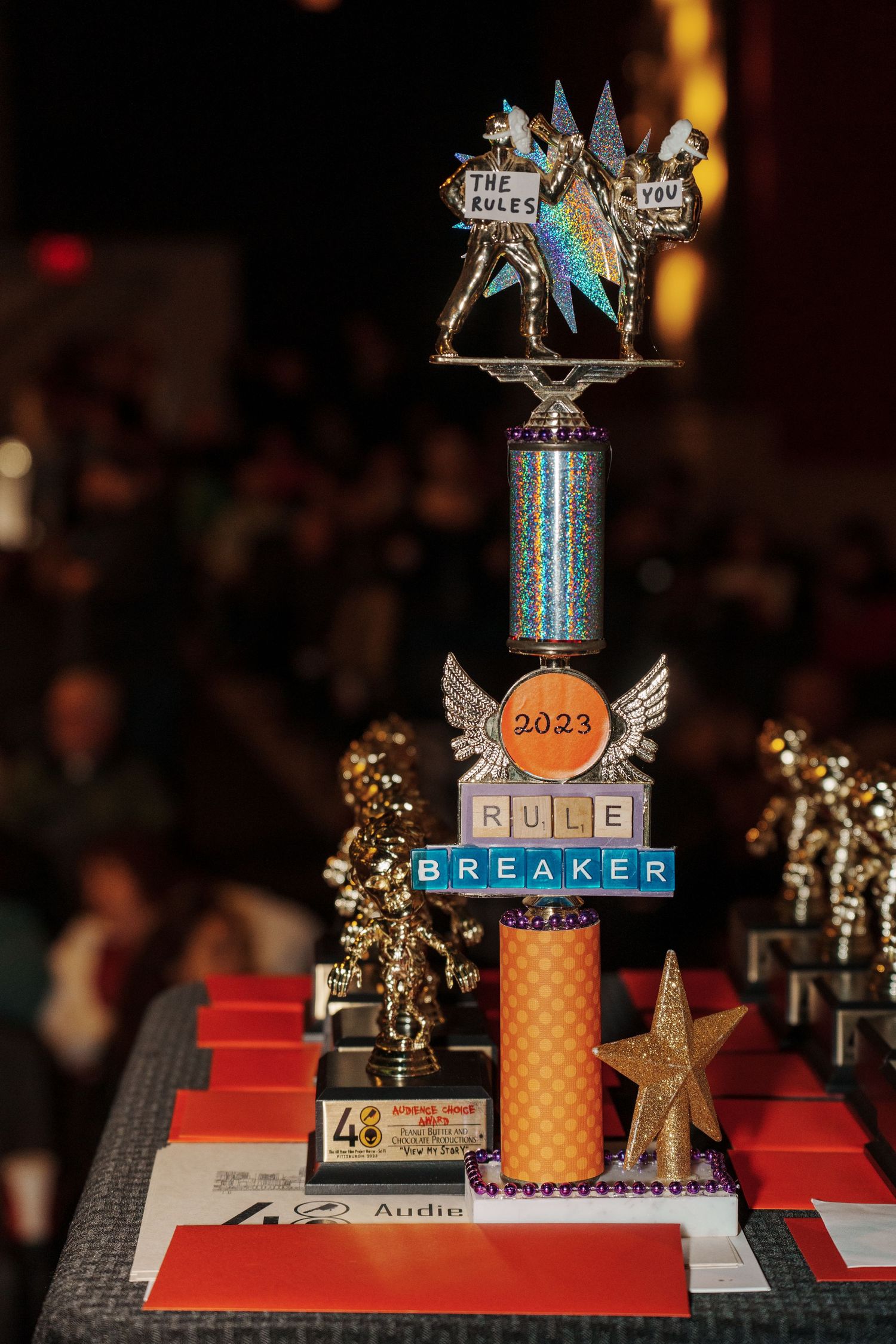 Decorative trophy awards with stars and metallic designs displayed on a red platform.