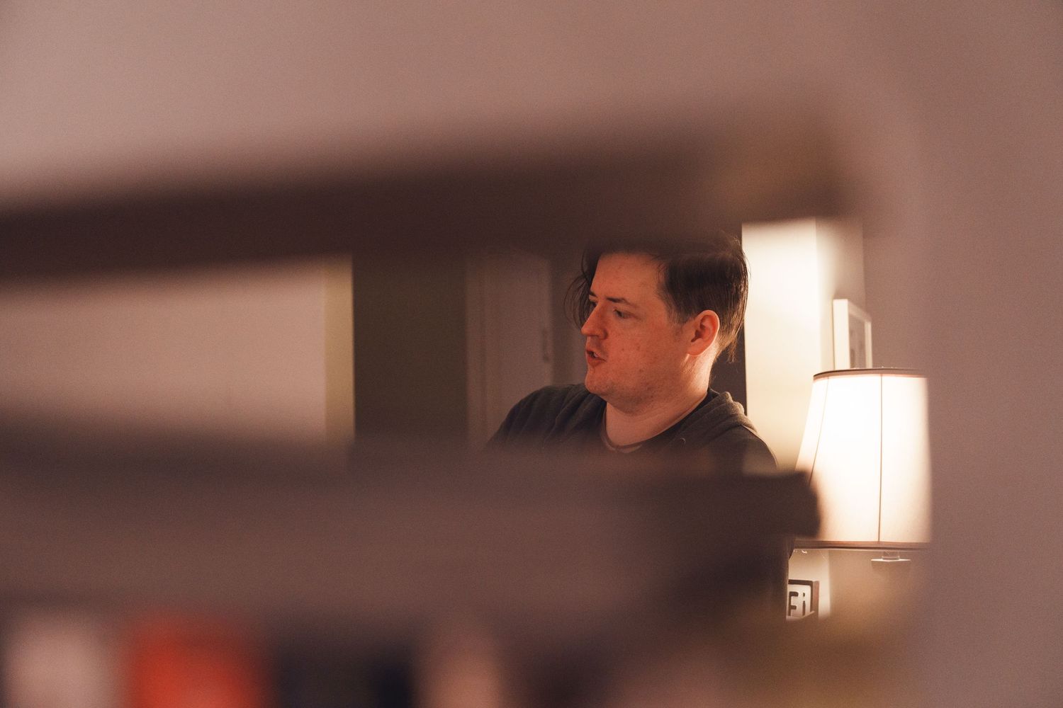 Blurred interior room scene with warm lighting and furniture silhouettes.