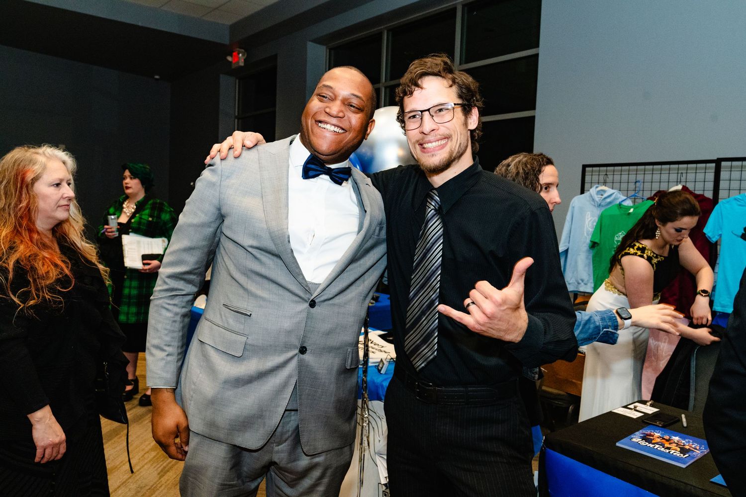 A group of people in formal attire socialize and interact at what appears to be a networking or business event.
