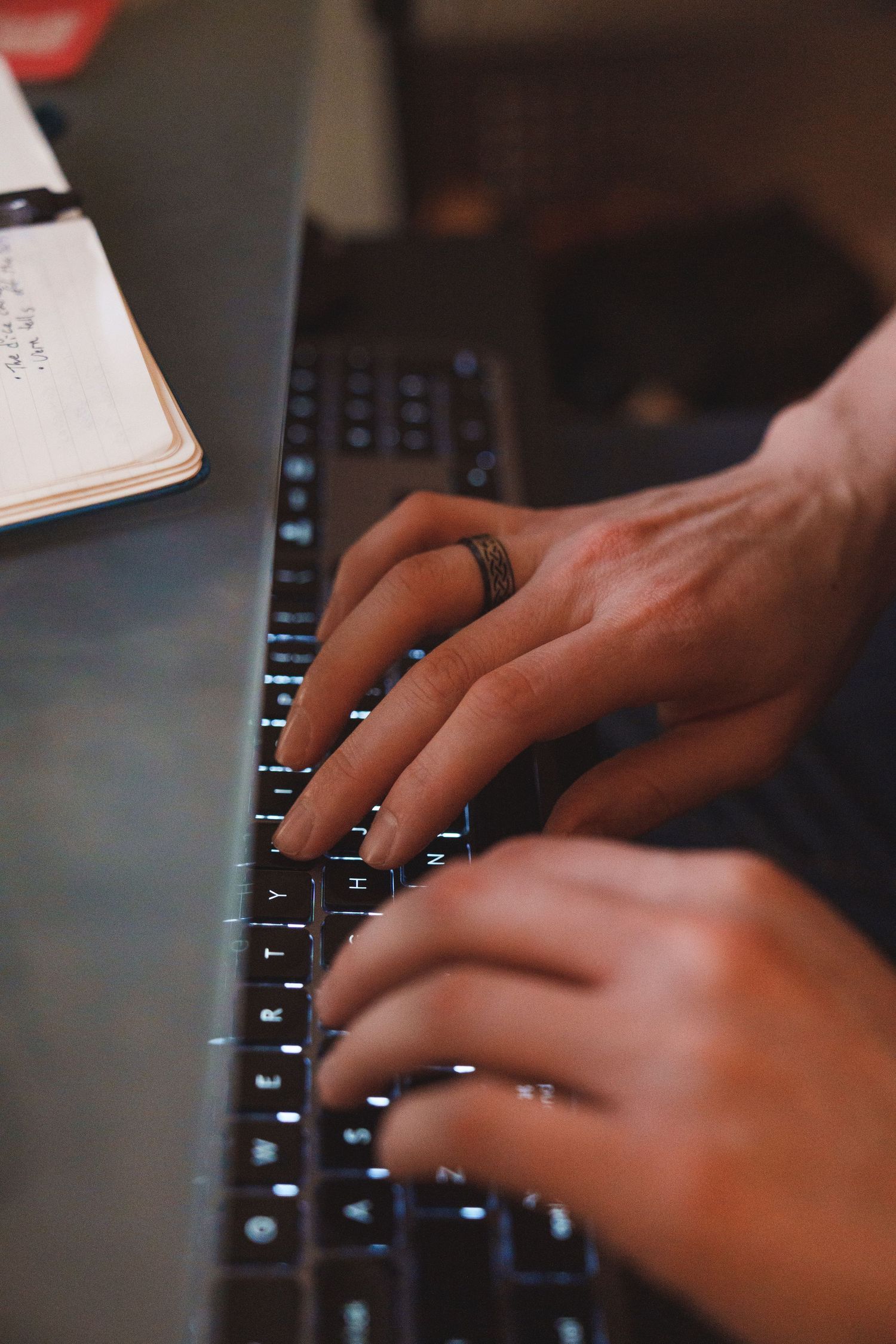 Close-up shot of hands typing on a black computer keyboard.