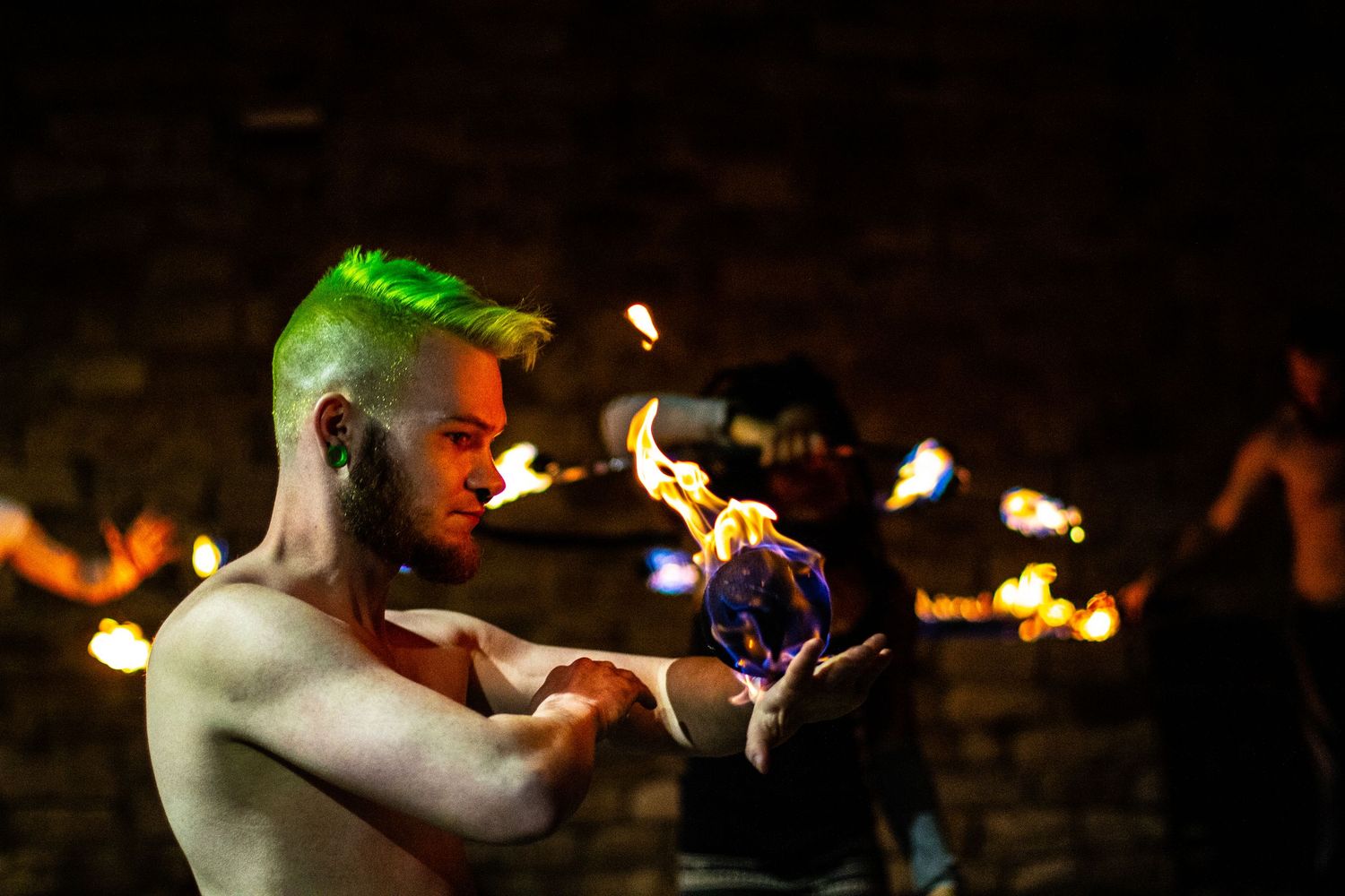 Fire performers creating dramatic light trails in the dark.