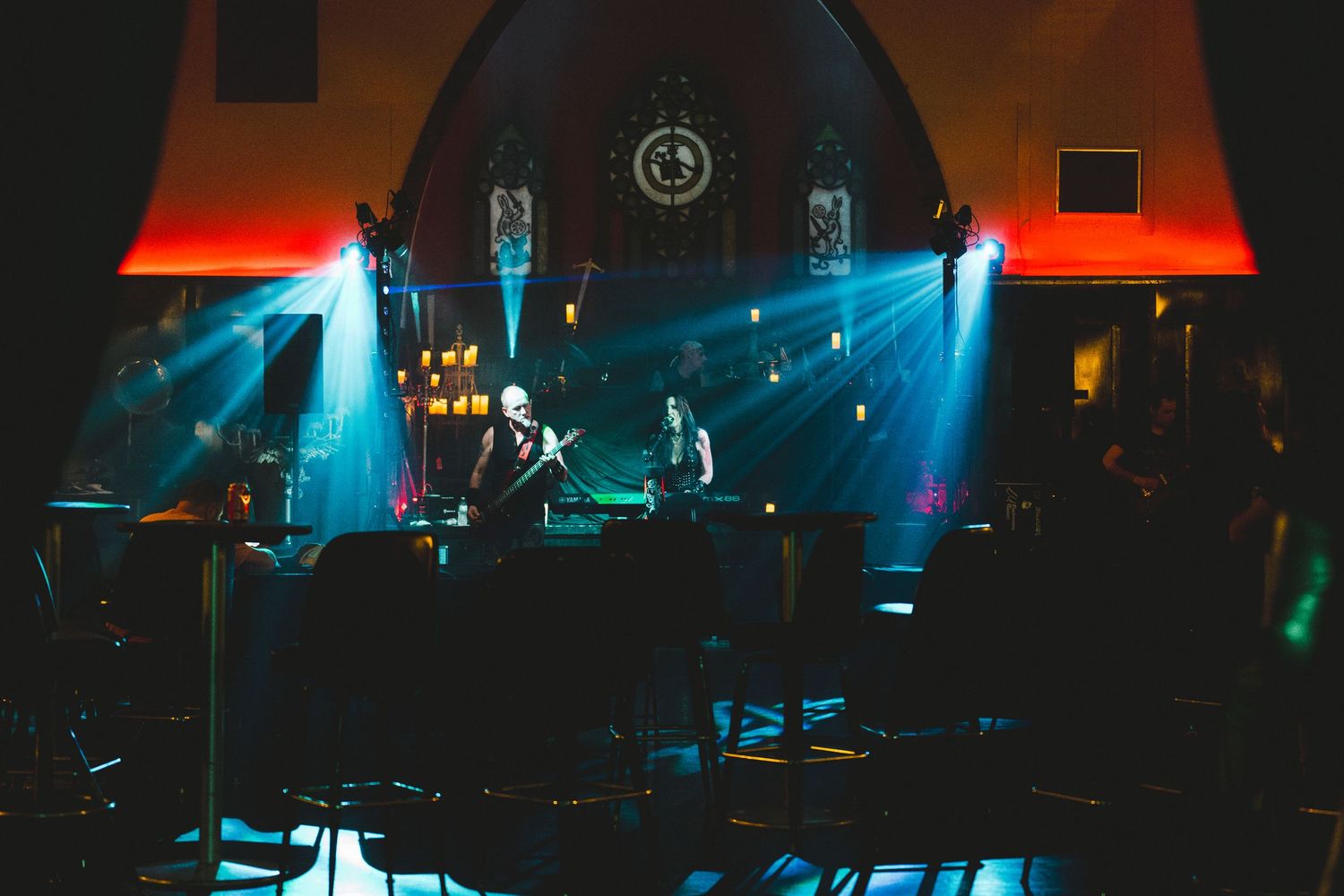 Concert stage illuminated with dramatic blue and red lighting during a live performance.