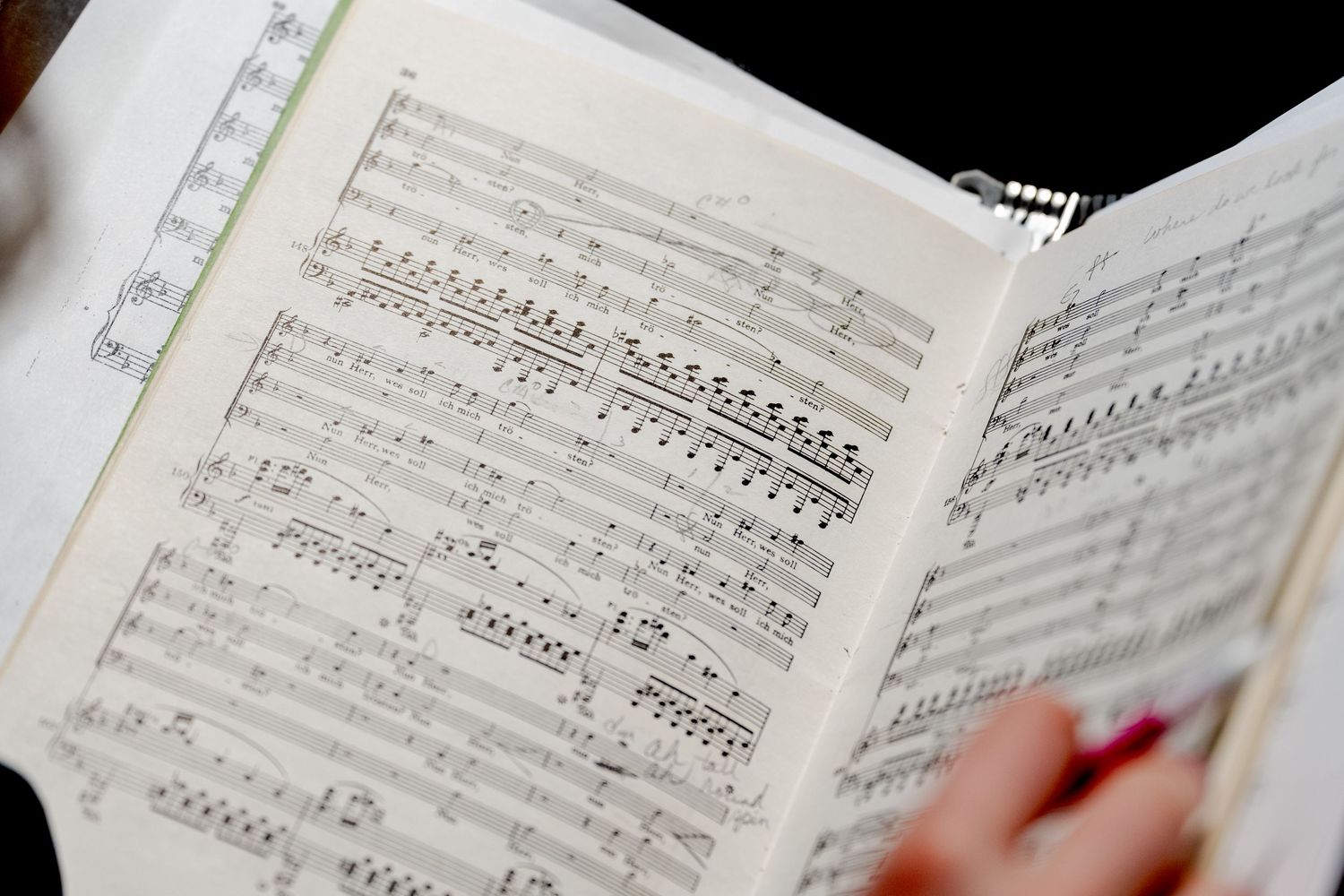 Sheet music pages showing musical notation and lyrics spread open on a surface.