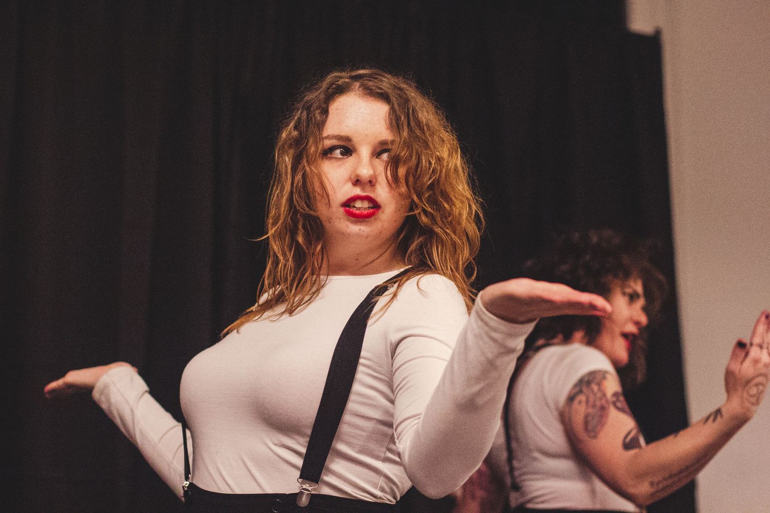 Dance performance featuring performers in white tops and dark bottoms on stage.