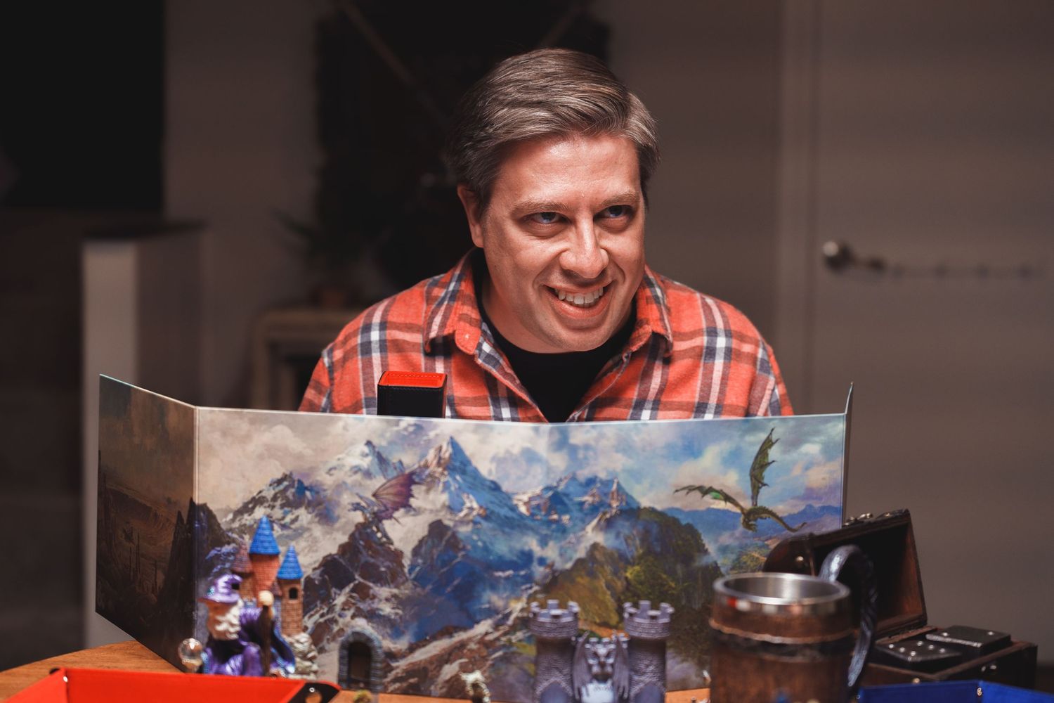 Person examines a detailed fantasy battle map laid out on a table.