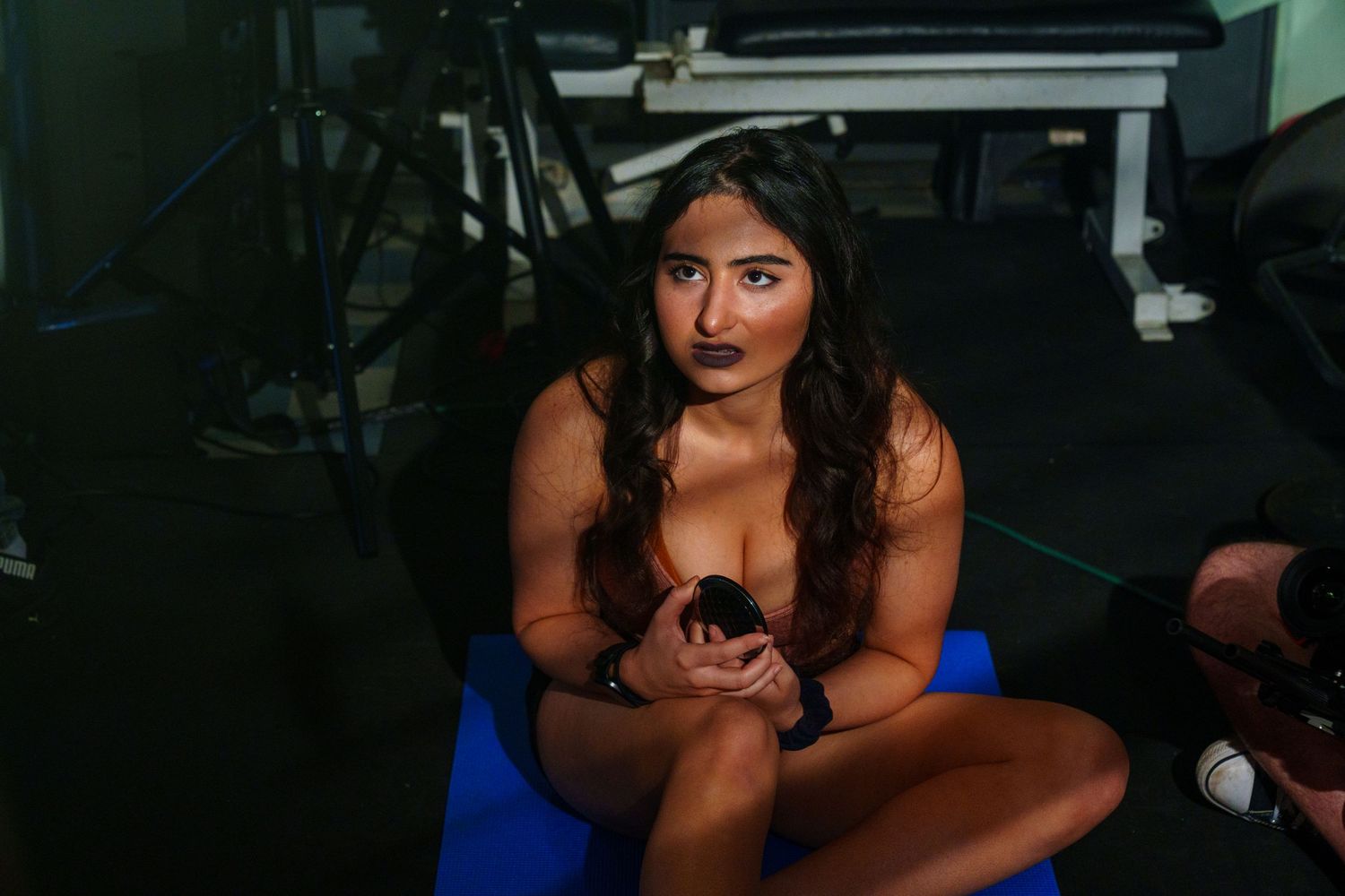 Dramatic close-up shots of someone in a blue outfit against a dark background.
