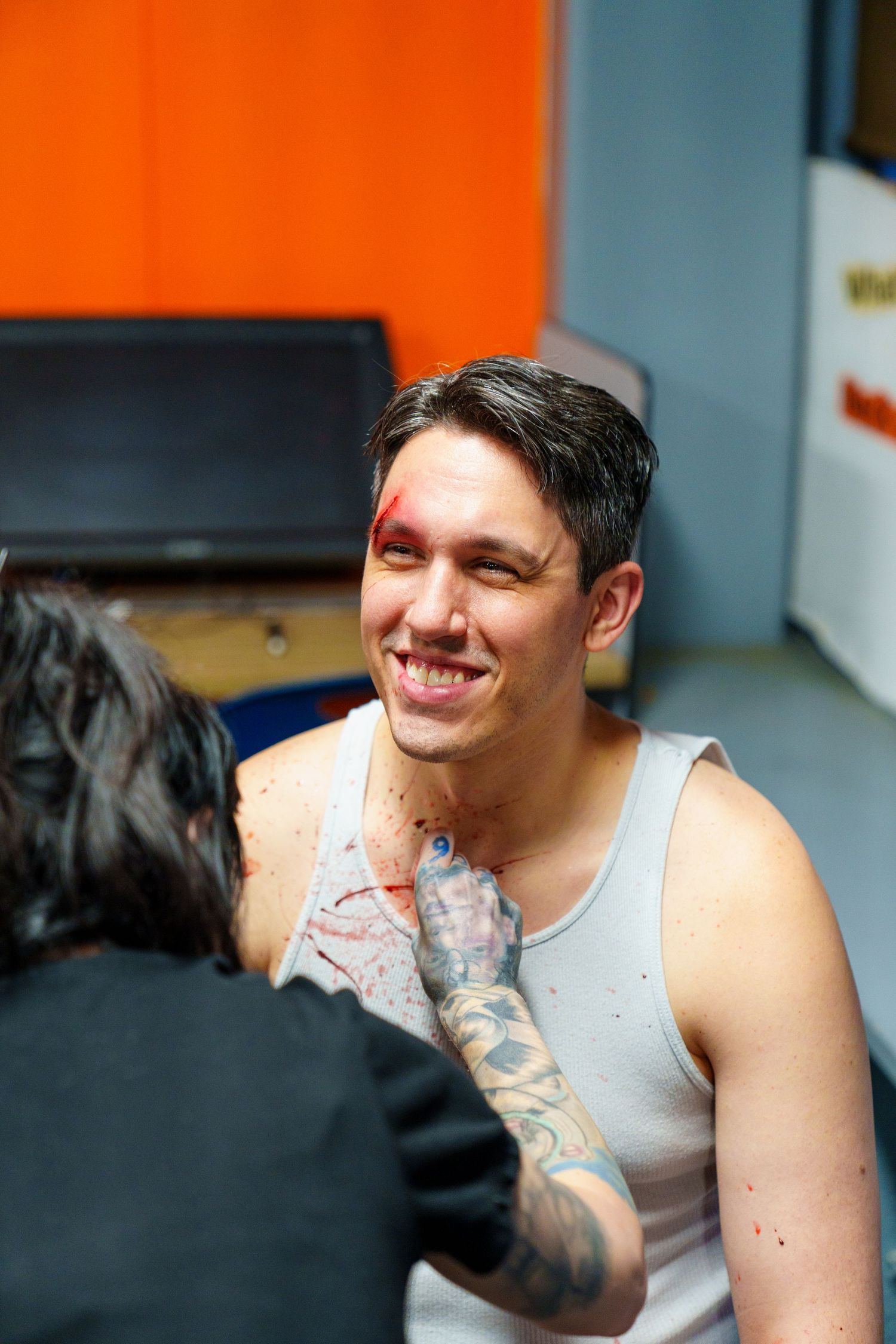Person in a tank top with tattoos shown in a series of casual portrait shots.