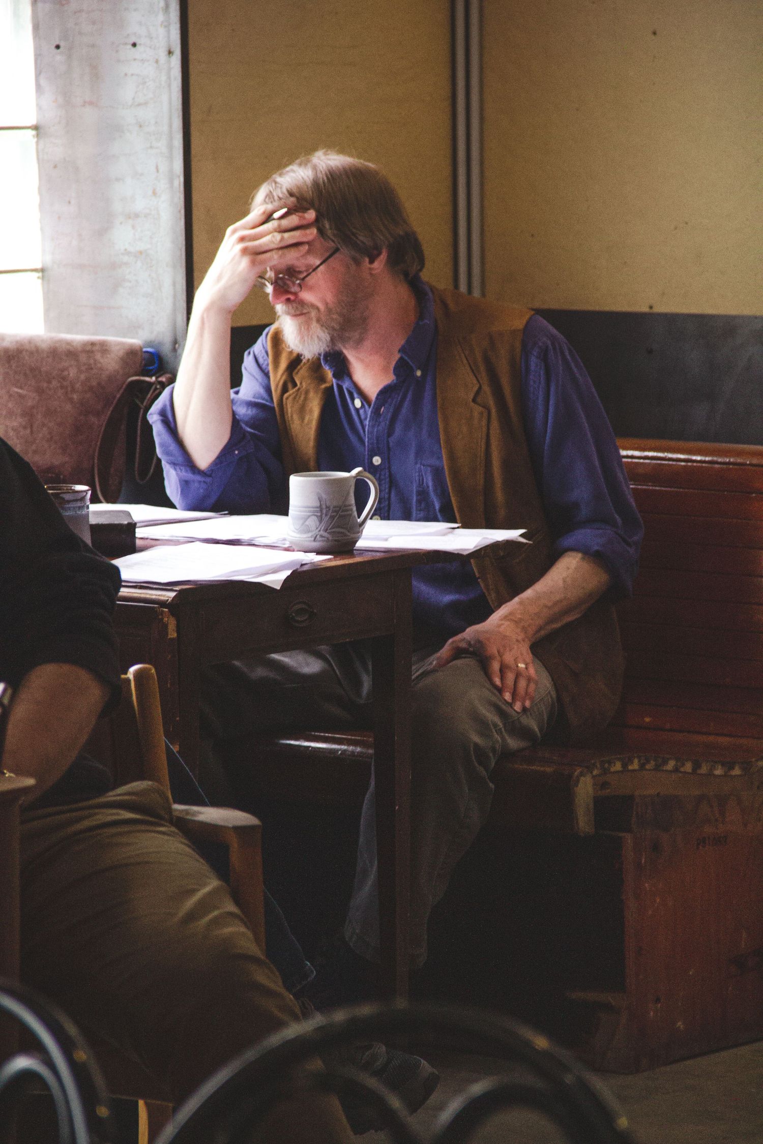 Person in blue clothing sits at a desk in contemplative poses across multiple frames.