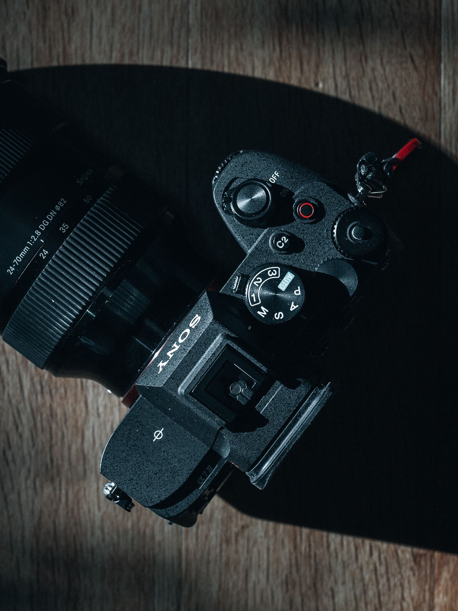 Close-up shots of camera equipment and lenses on a wooden surface in low light conditions.